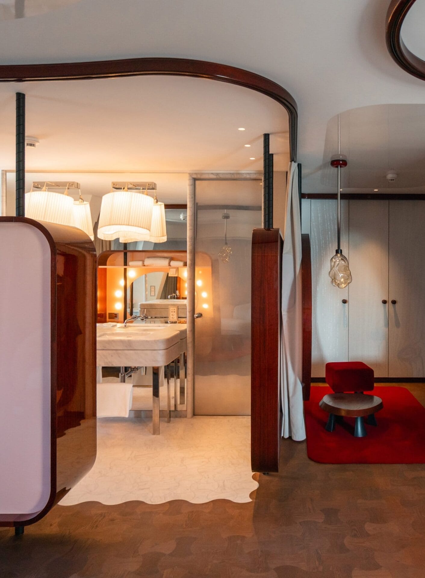 Interieur van een suite in Hotel Les Trois Rois met mahoniekleurige kasten, rood velours en een marmeren wastafel