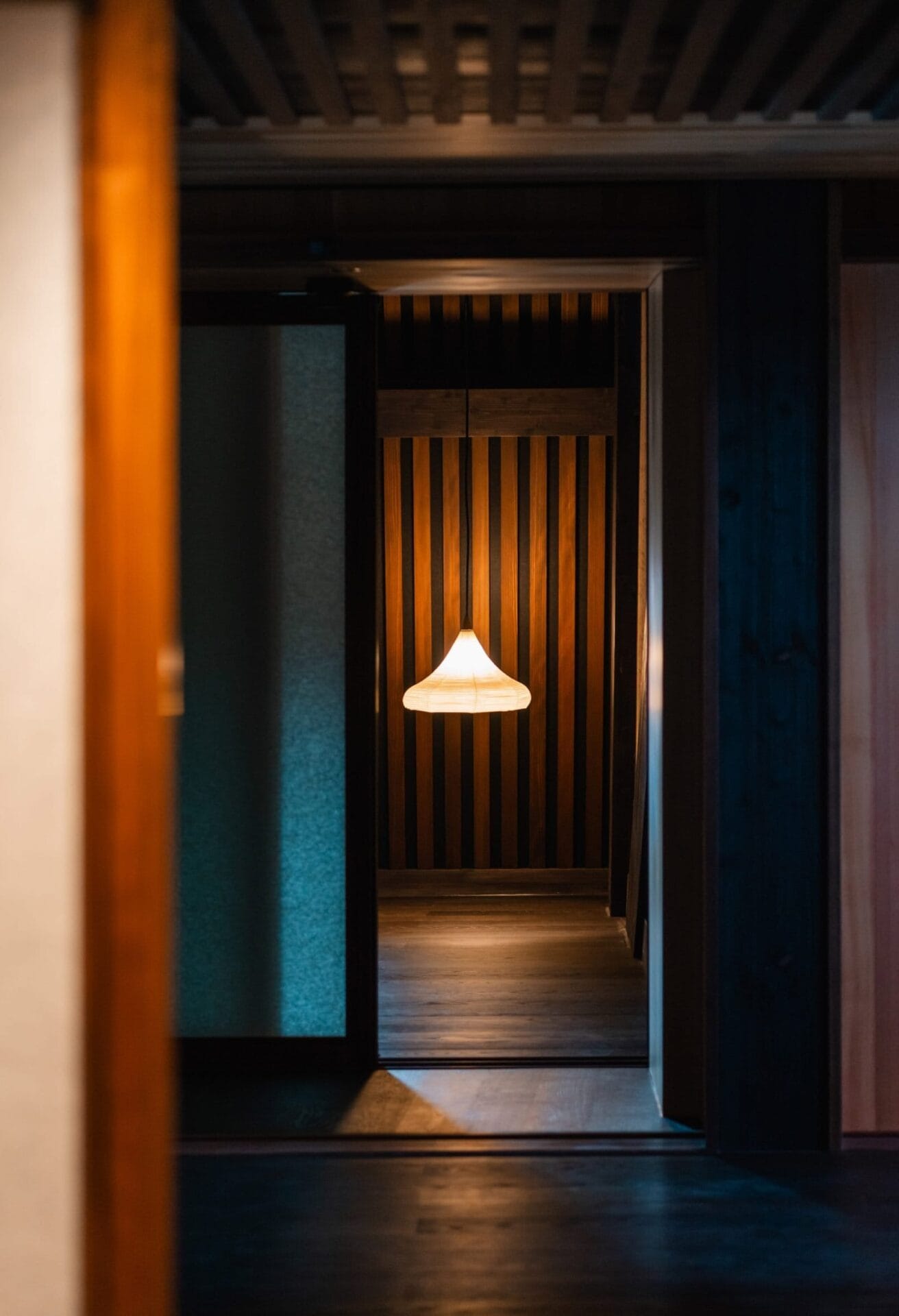 Minimalistisch interieur van de spa in Hotel Les Trois Rois met houten lattenwanden en een hanglamp in Japanse stijl