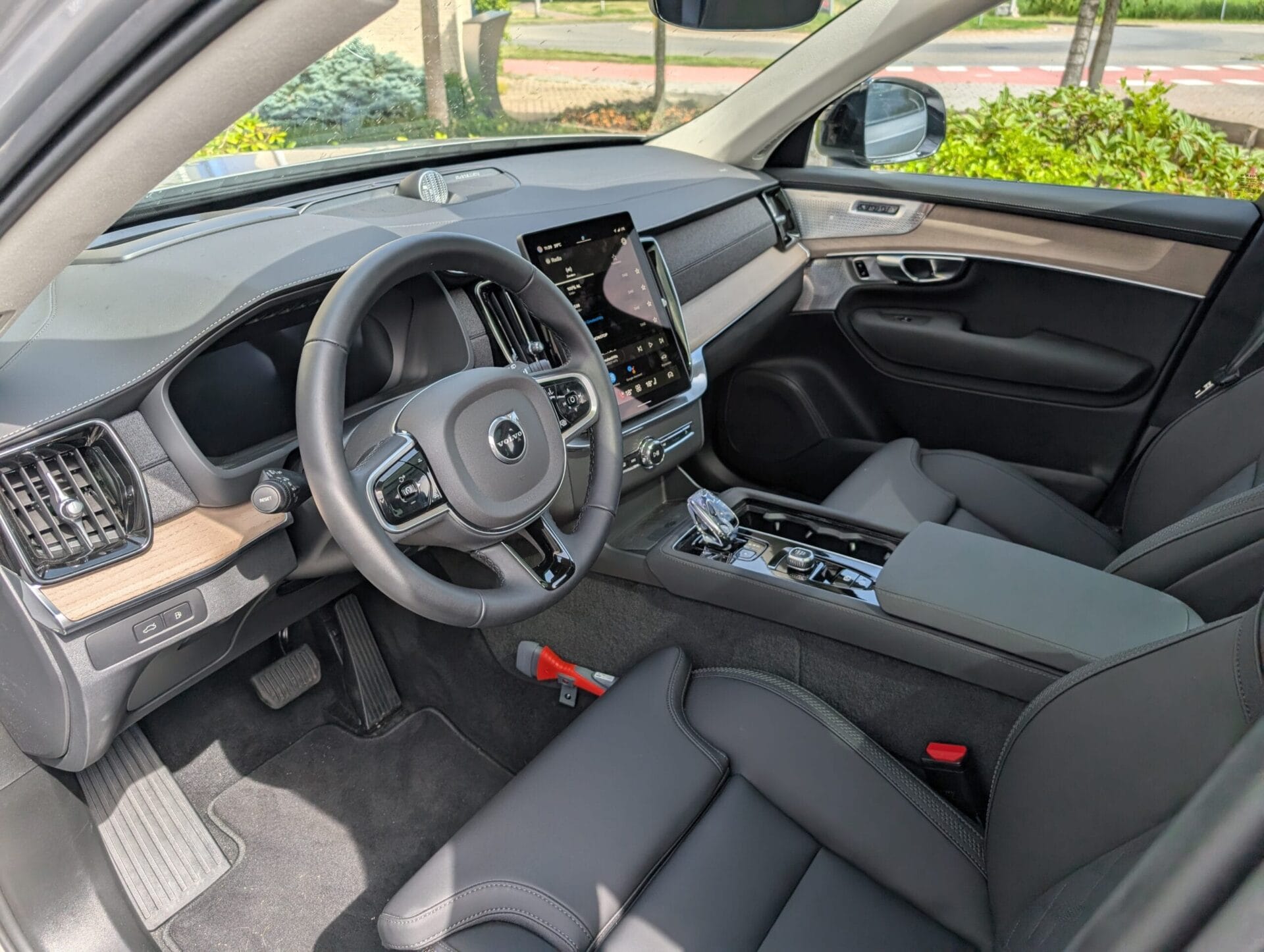 Het luxe interieur van de Volvo XC90 met lederen stoelen, houten details en een centraal tablet-scherm