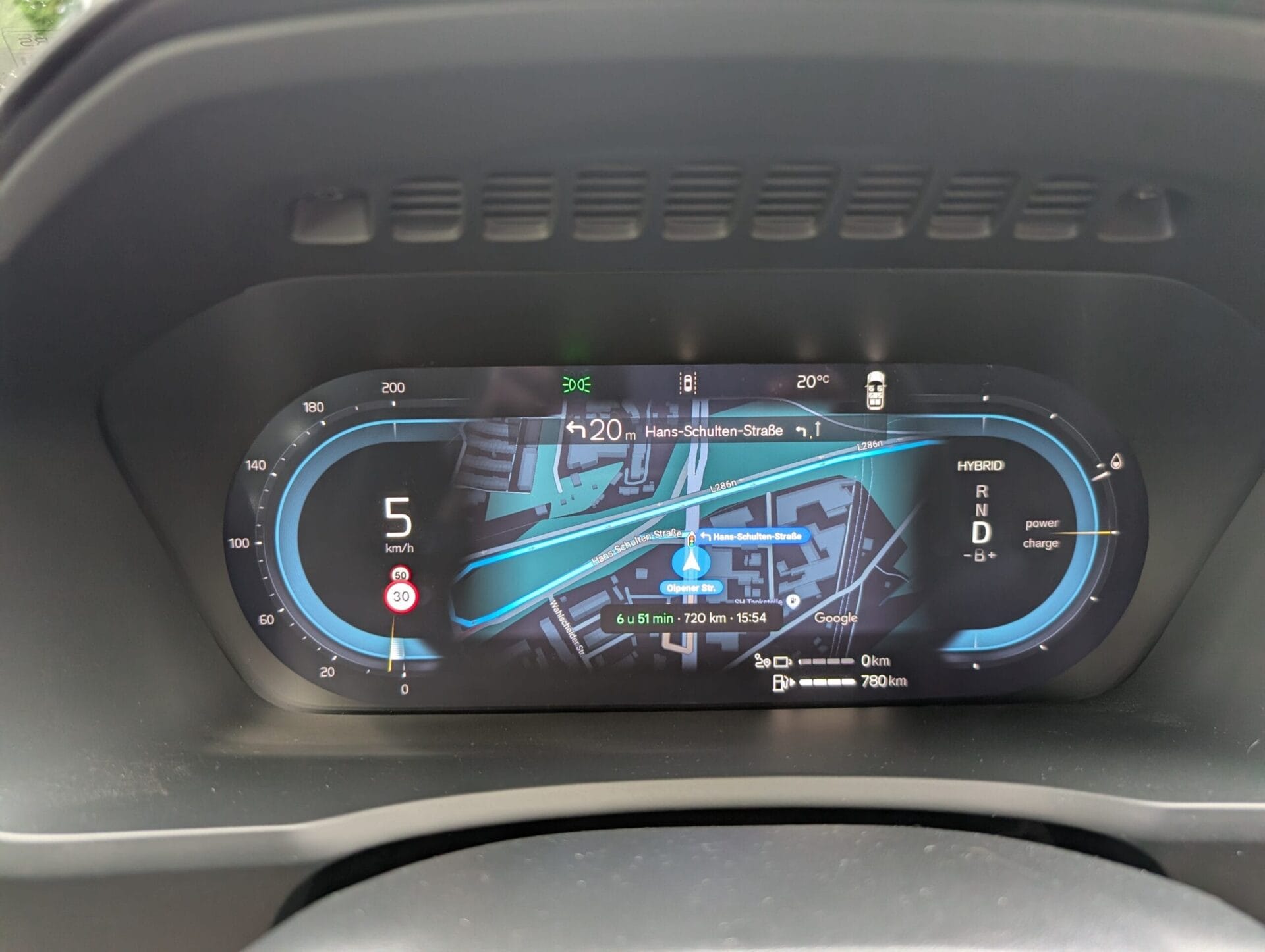 Digitaal dashboard van de Volvo XC90 met Google Maps navigatie tussen de snelheidsmeter en de hybride vermogensmeter