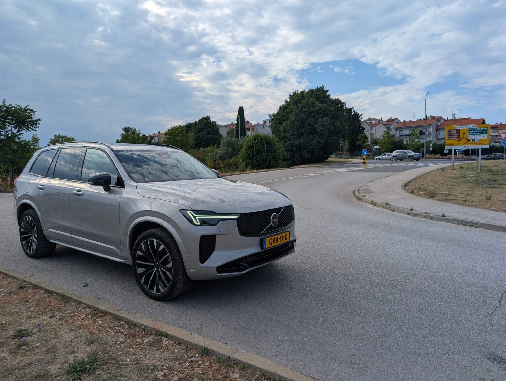 Zilverkleurige Volvo XC90 T8 geparkeerd langs een weg in Kroatië onder een lichtbewolkte hemel
