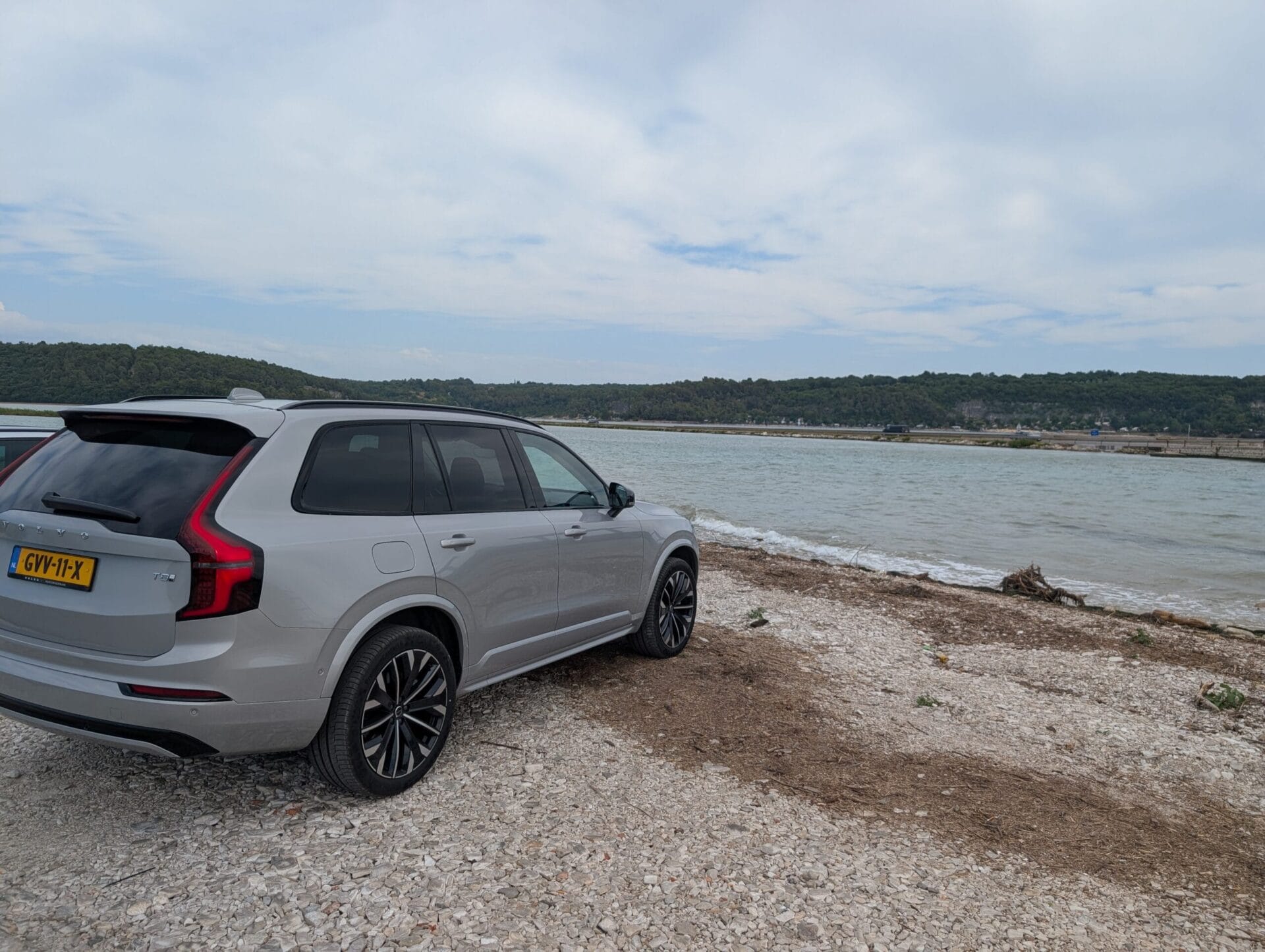 Zijaanzicht van een grijze Volvo XC90 geparkeerd op een kiezelstrand aan de Kroatische kust