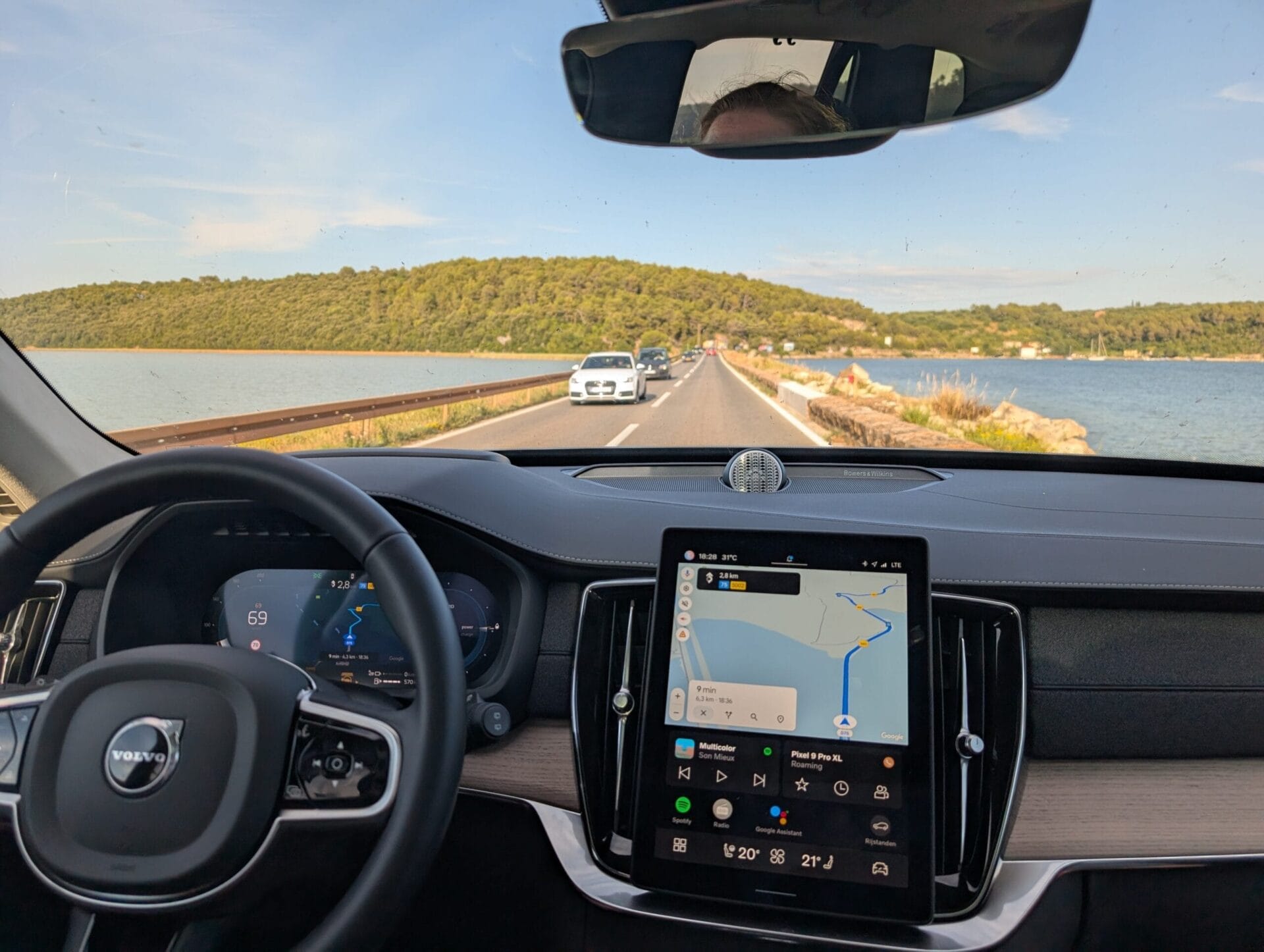 Uitzicht vanuit de cockpit van een Volvo XC90 rijdend over een weg langs het water in Kroatië