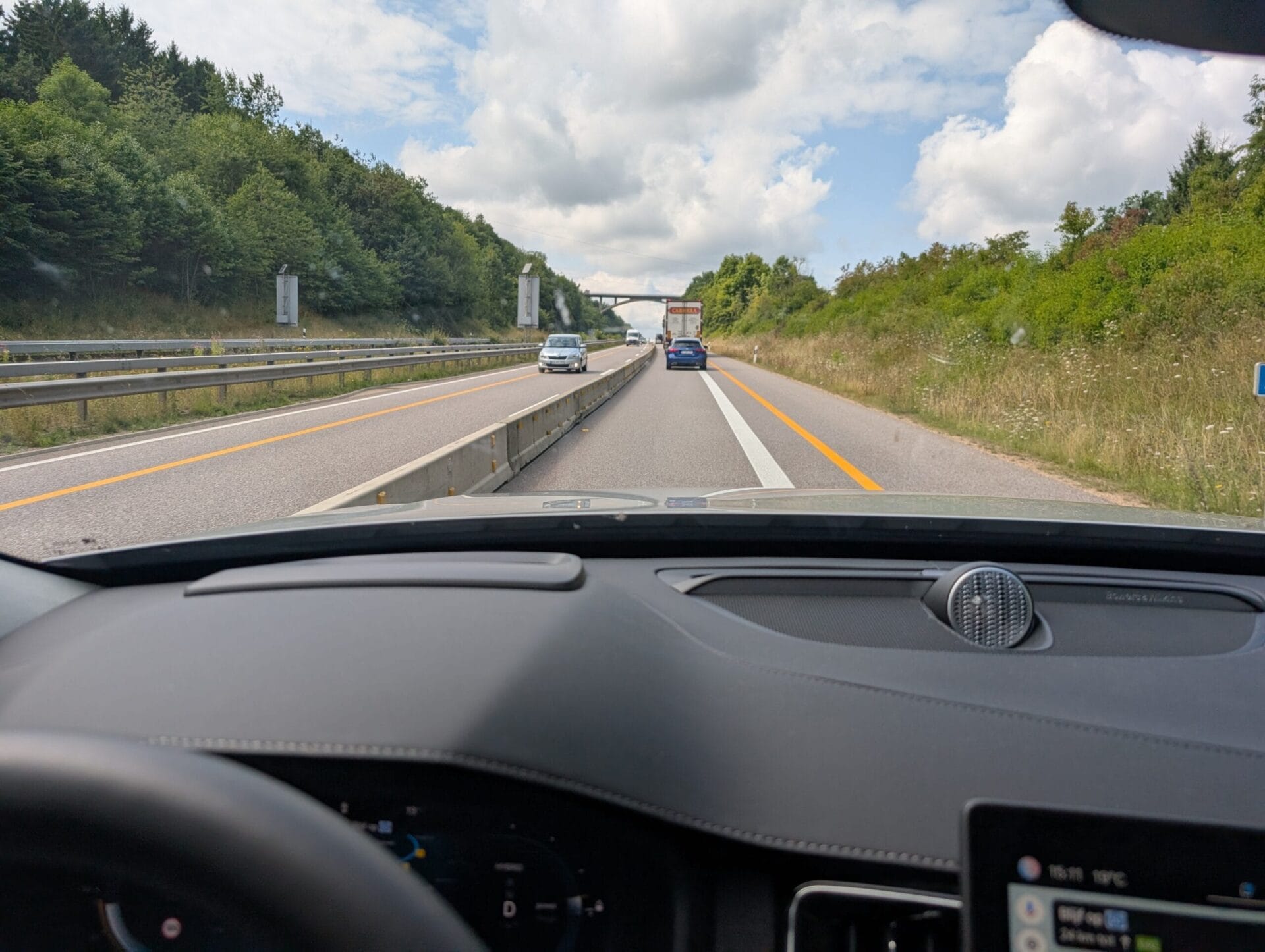 Uitzicht vanuit de Volvo XC90 op de Duitse Autobahn met wegwerkzaamheden en een Bowers & Wilkins luidspreker op het dashboard