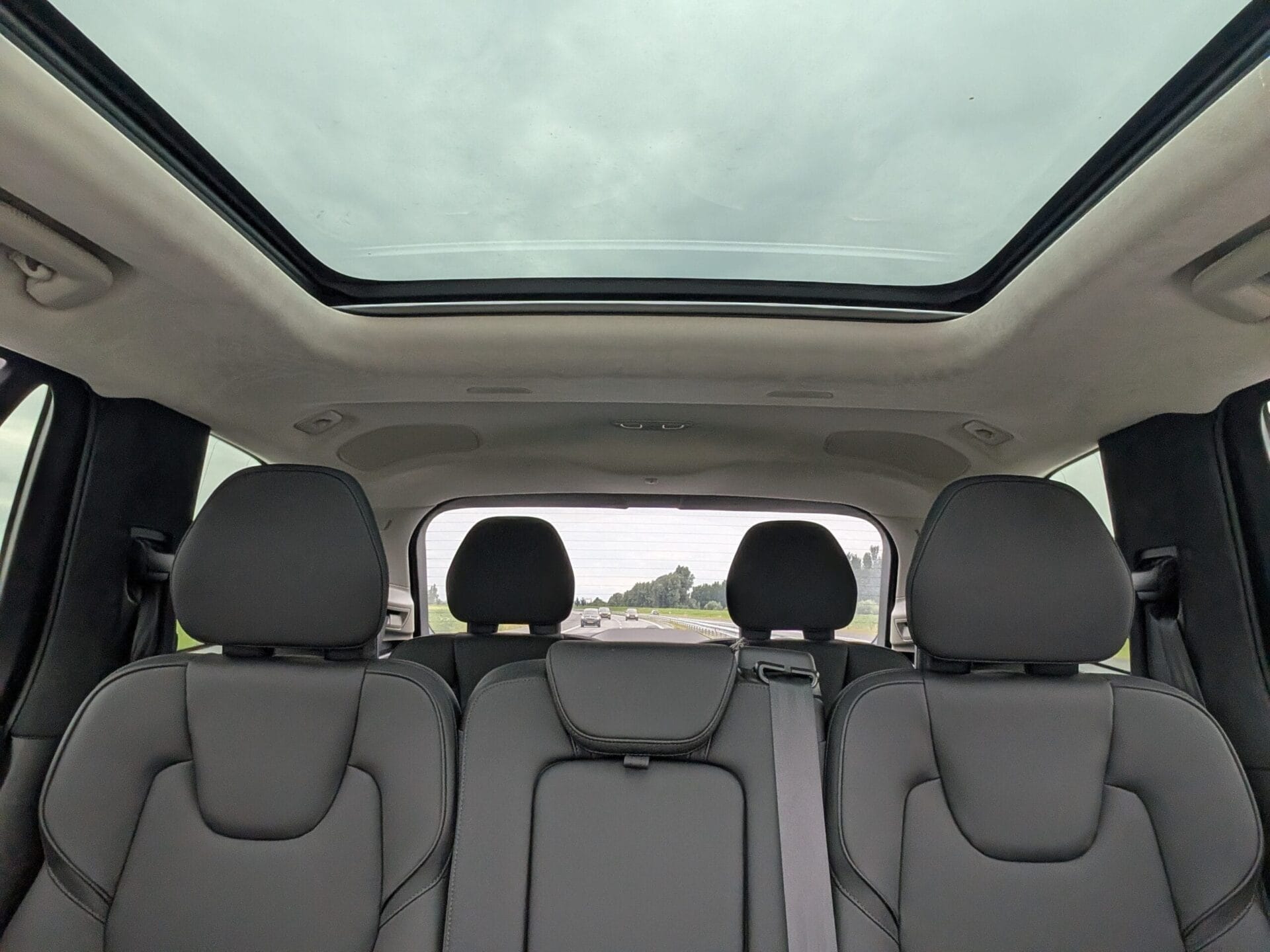 Zicht vanuit de achterbank van een Volvo XC90 op het grote glazen panoramadak en de ruime cockpit