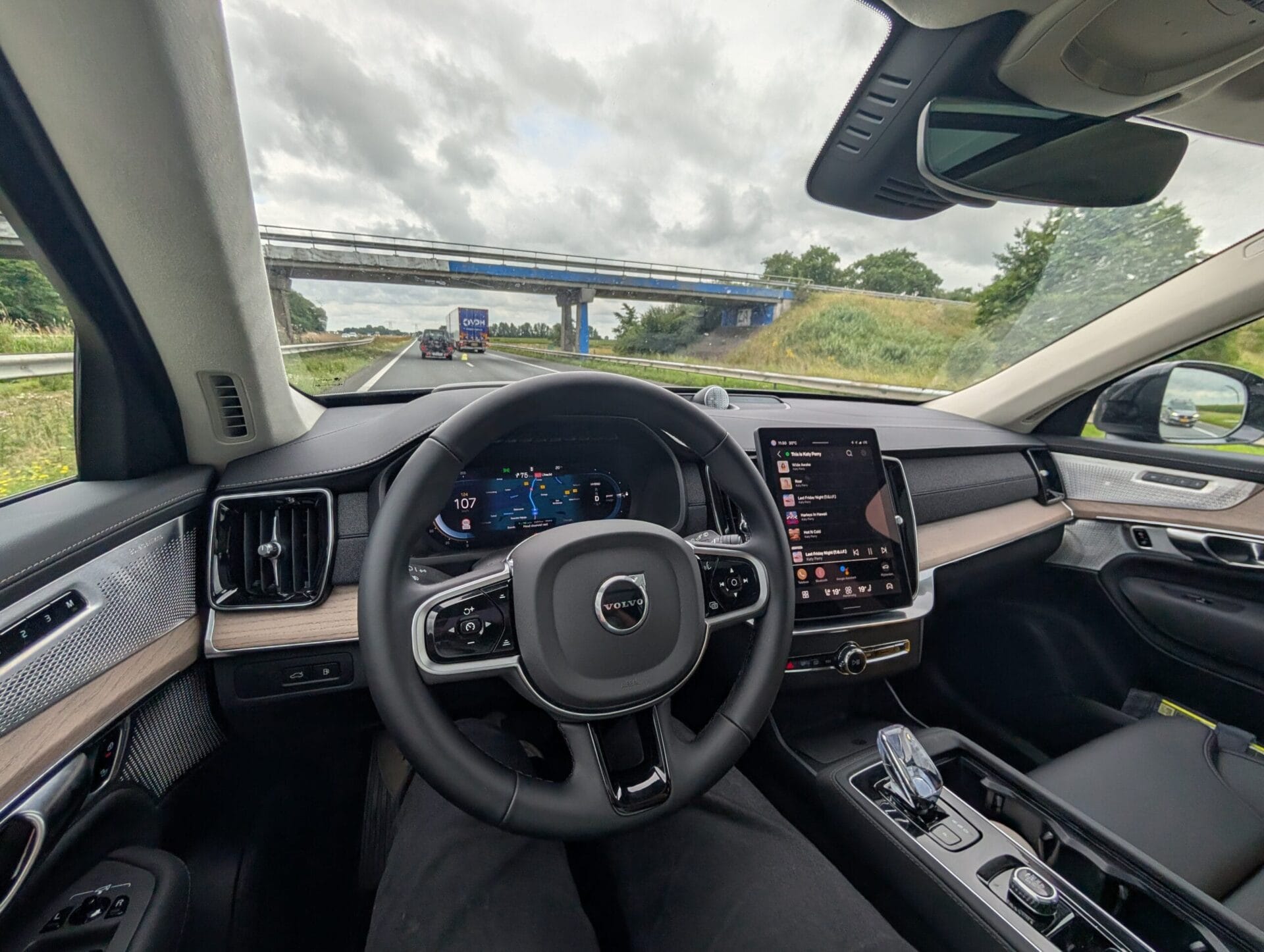 Interieur van de Volvo XC90 T8 met zicht op het digitale dashboard en de centrale tablet tijdens een rit op de snelweg