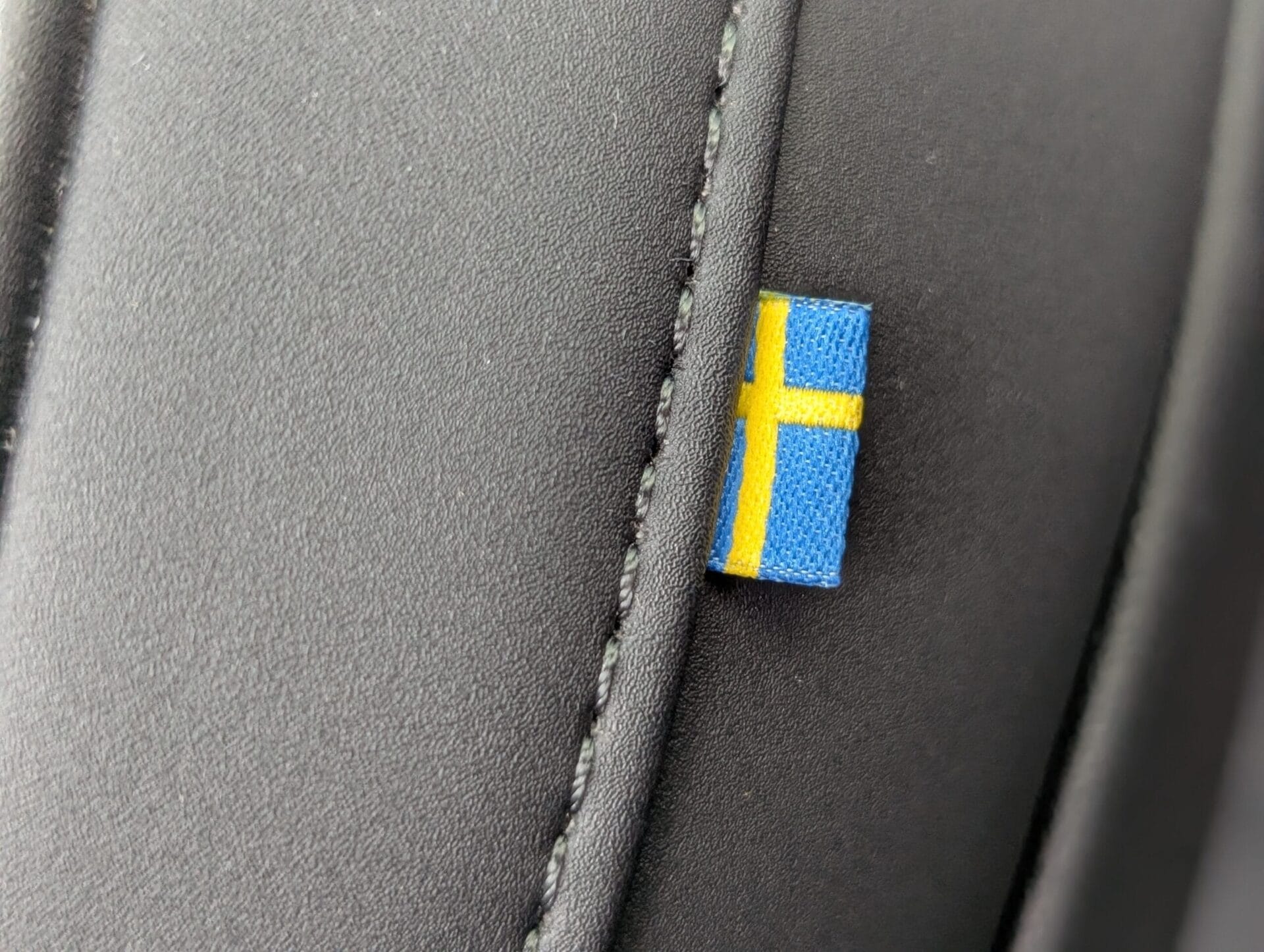 Detail van de lederen bekleding van de Volvo XC90 met een klein label van de Zweedse vlag bij de naad