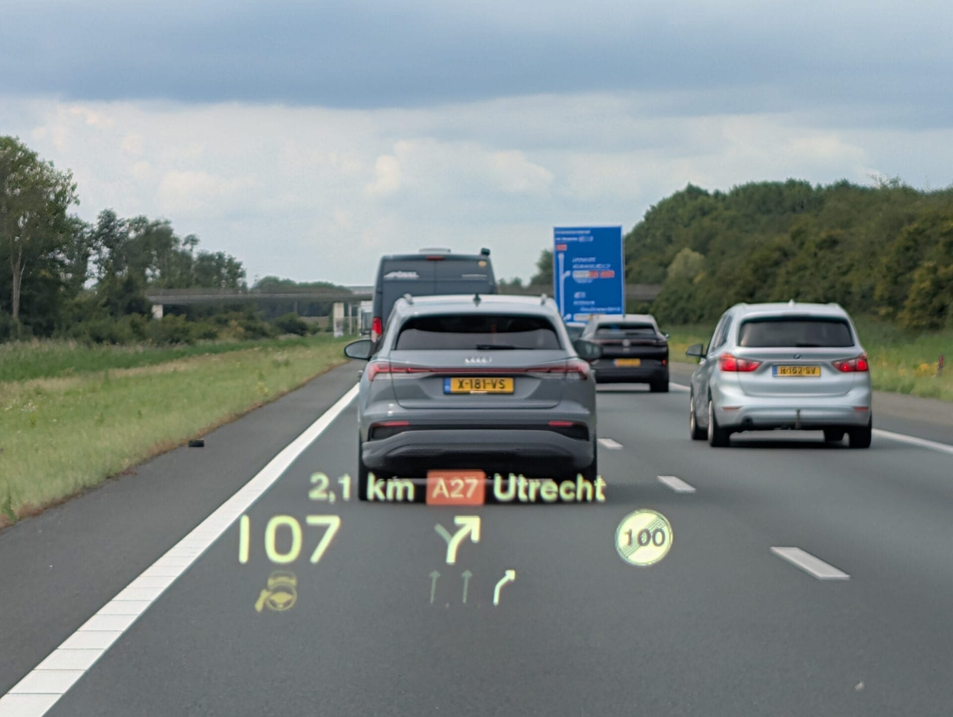 Heads-up display op de voorruit toont navigatie naar de A27 Utrecht, de snelheid van 107 km/u en rijstrookbegeleiding