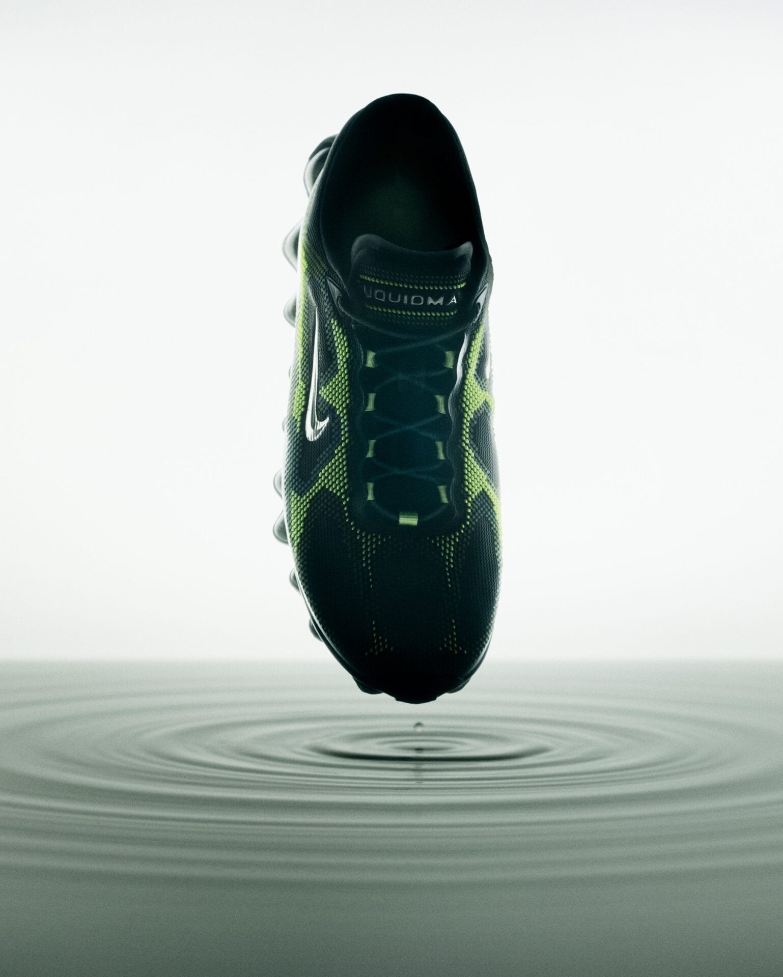 Bovenaanzicht van de Nike Air Liquid Max sneaker met gifgroene patronen, zwevend boven rimpelend water