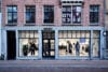 Voorgevel van de Carhartt WIP winkel in een bakstenen gebouw met etalages waarin kleding op etalagepoppen wordt getoond