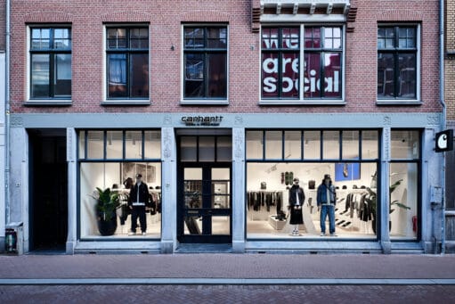Voorgevel van de Carhartt WIP winkel in een bakstenen gebouw met etalages waarin kleding op etalagepoppen wordt getoond