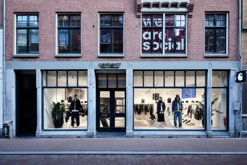 Voorgevel van de Carhartt WIP winkel in een bakstenen gebouw met etalages waarin kleding op etalagepoppen wordt getoond