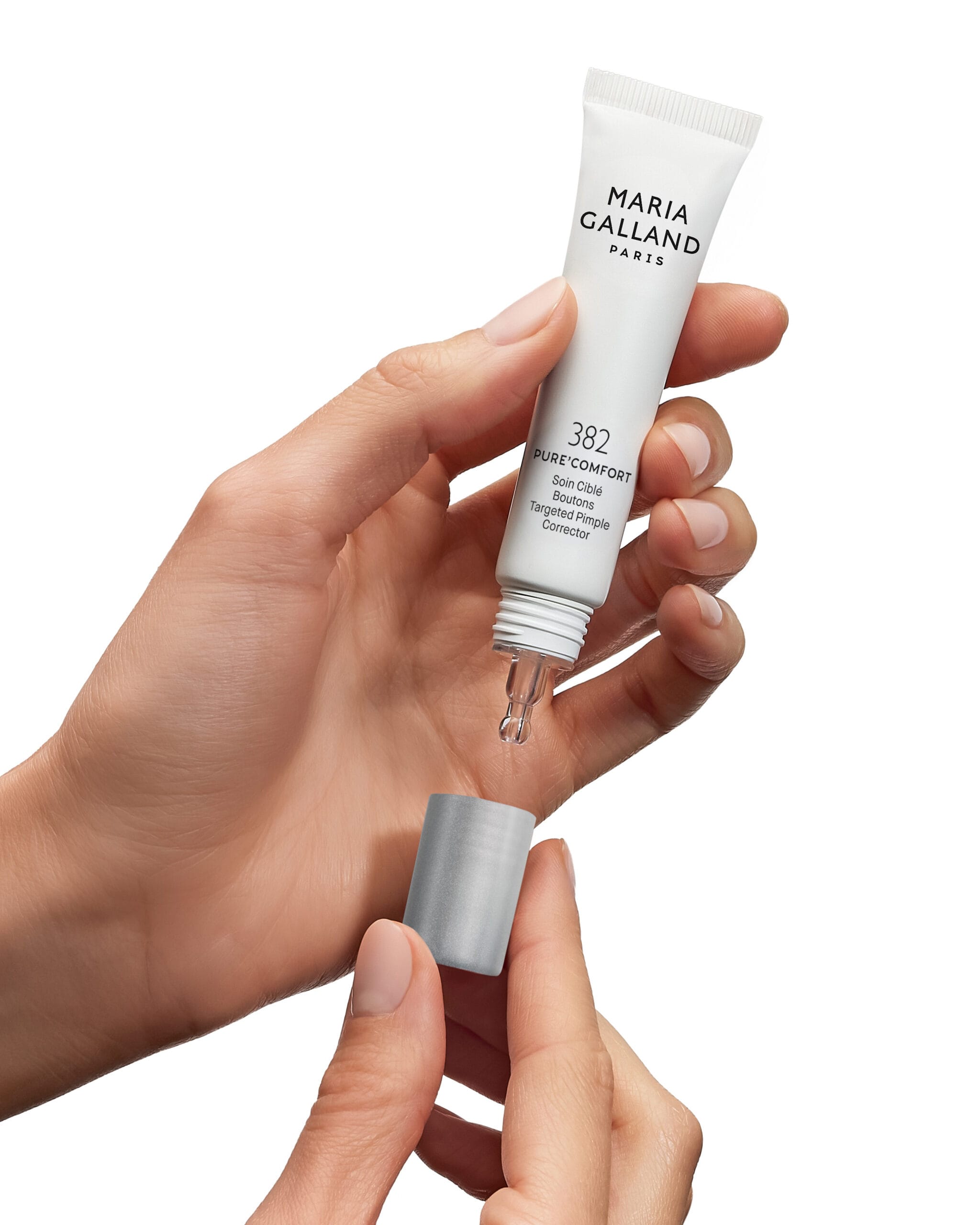 Een hand houdt een geopende tube Maria Galland 382 Pure'Comfort Targeted Pimple Corrector vast