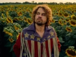 muzikant Kevin Morby staat in een veld vol zonnebloemen