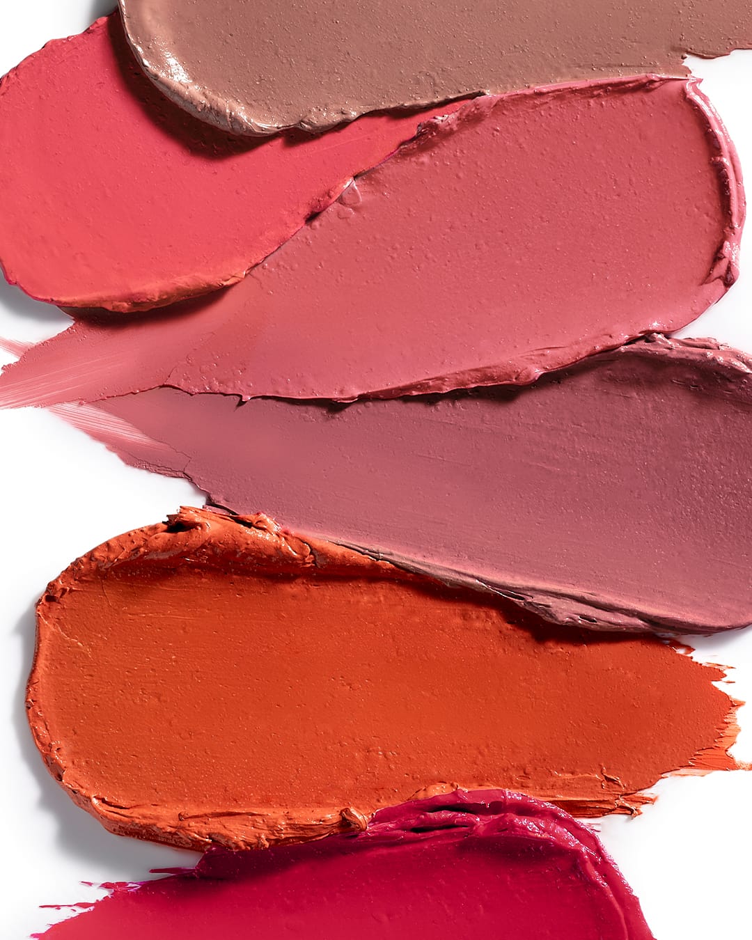 Maria Galland - 880 - creamy lipstick - Verschillende dikke vegen lippenstift in tinten roze, nude, oranje en bessenrood op een witte achtergrond