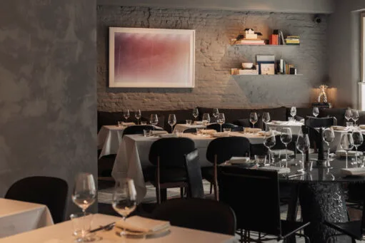 Modern en warm ingericht restaurantinterieur met houten tafels en stoelen.