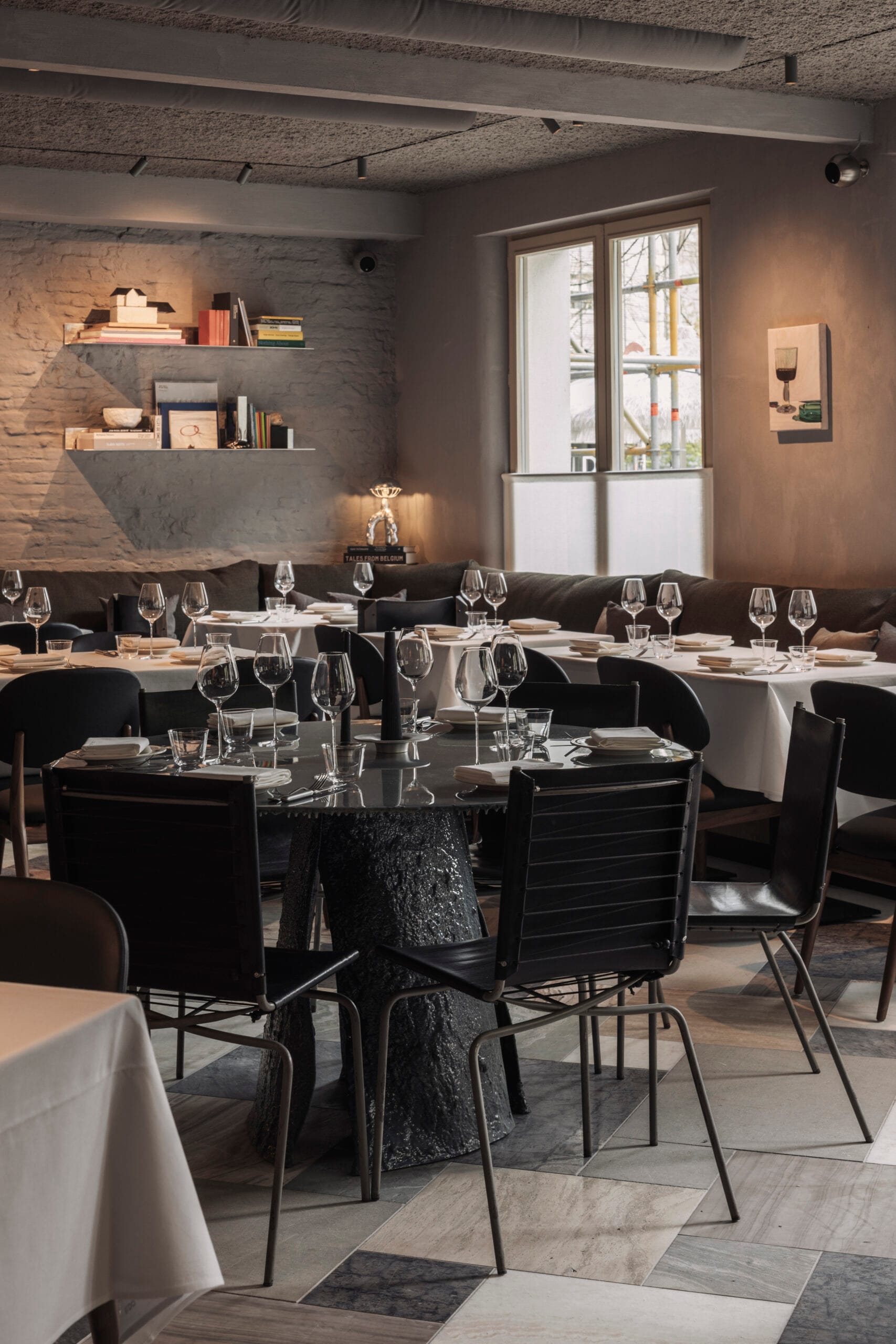 Modern en warm ingericht restaurantinterieur met houten tafels en stoelen.
