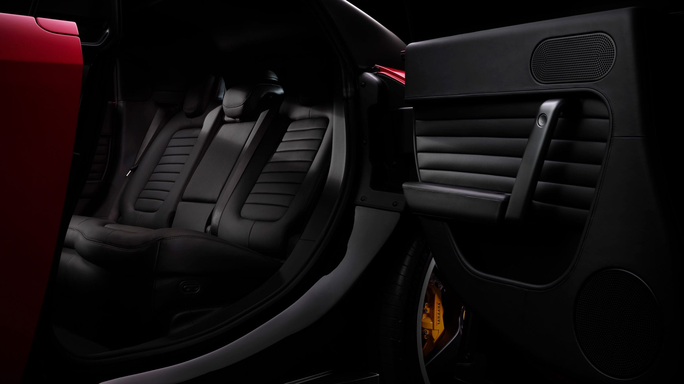 Zijaanzicht van de achterbank en het geopende achterportier van een luxe auto met zwart lederen interieur