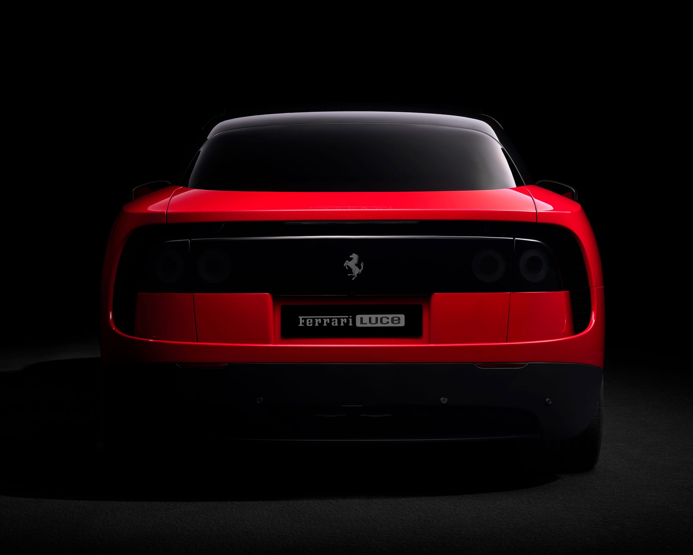 Achteraanzicht van een rode Ferrari Luce tegen een zwarte achtergrond