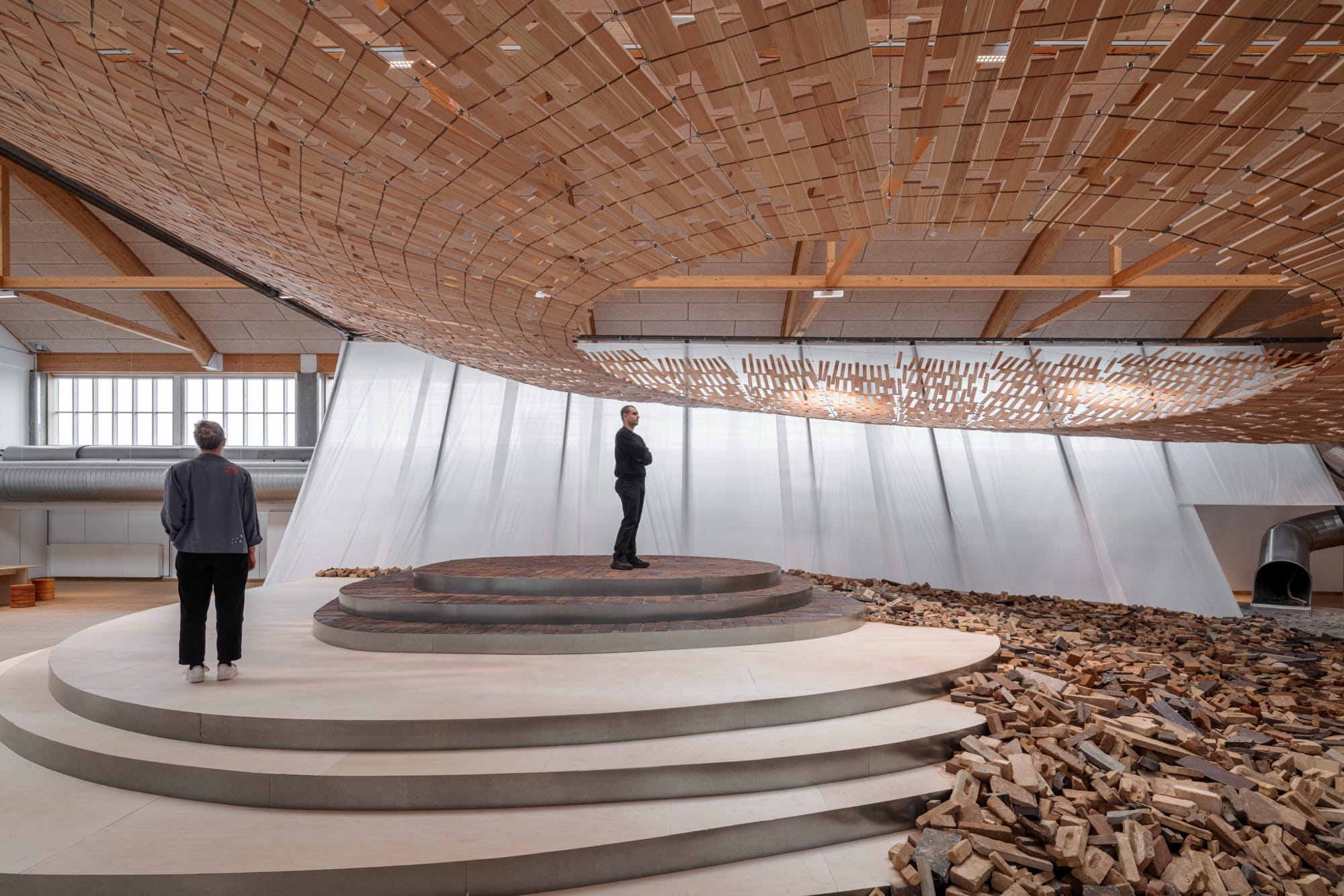 De houten lattenstructuur gefotografeerd tegen de achtergrond van de museumzaal