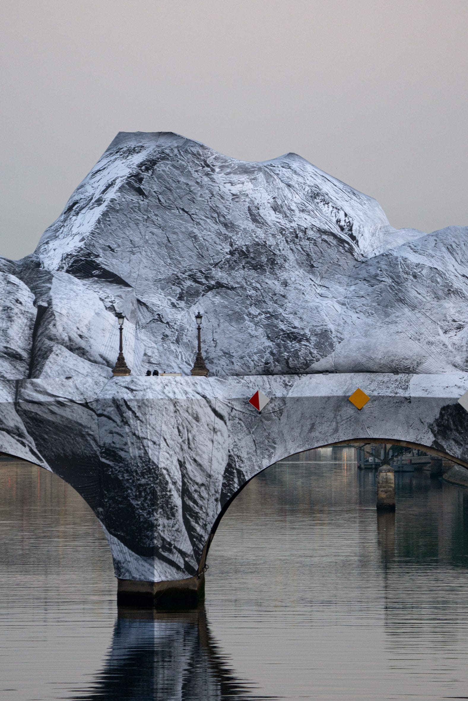 De Pont Neuf in Parijs volledig ingepakt in doeken met een zwart-wit print van besneeuwde bergtoppen
