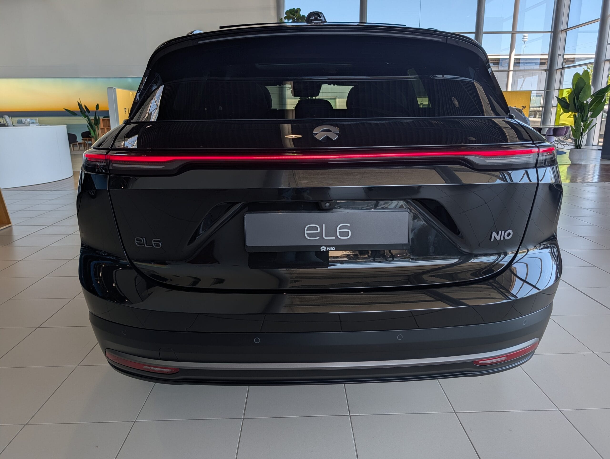 Achteraanzicht van een zwarte NIO EL6 in een showroom met brandende achterlichten