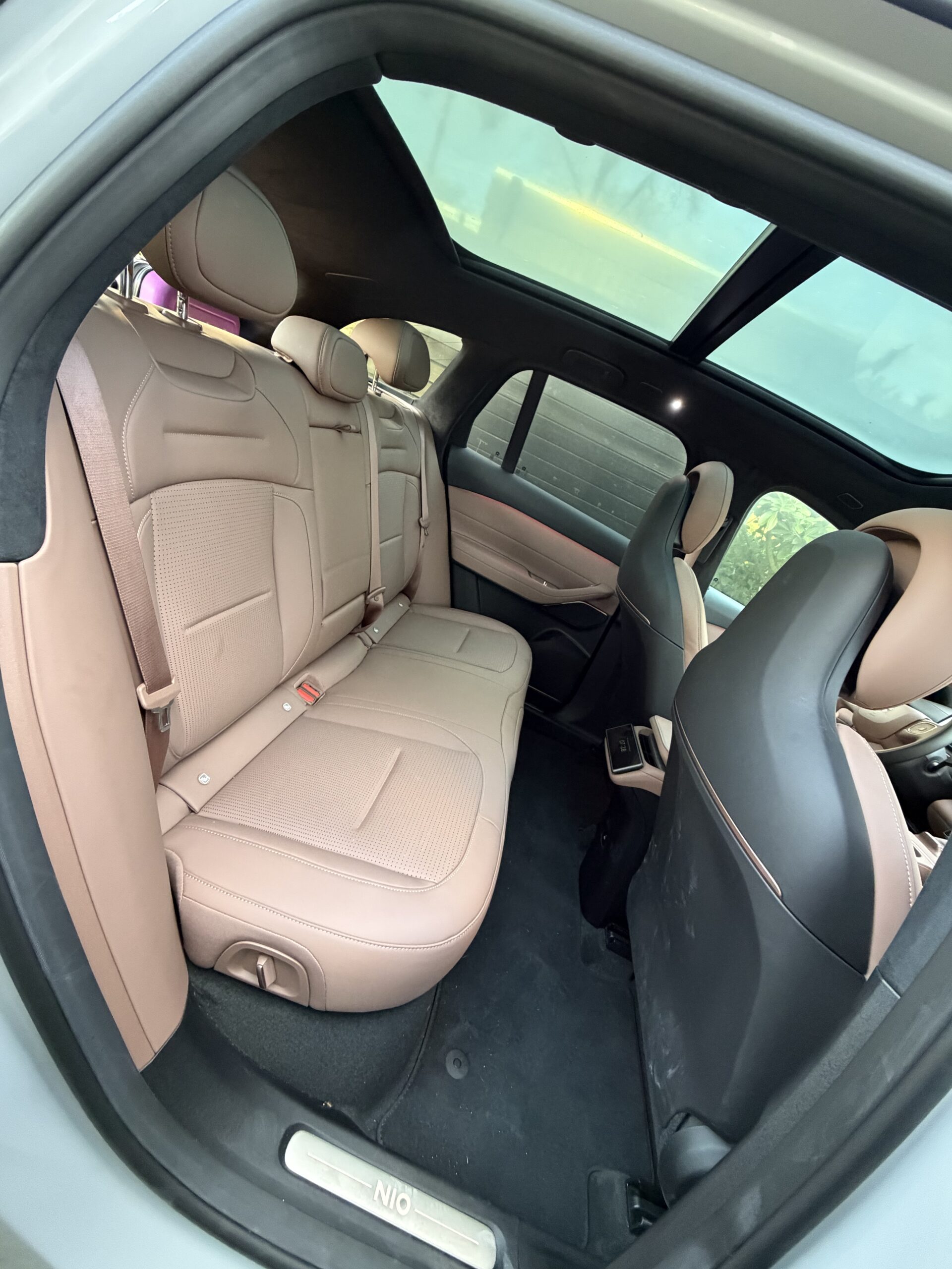 Interieur van een NIO met beige lederen achterbank en een groot panoramisch glazen dak