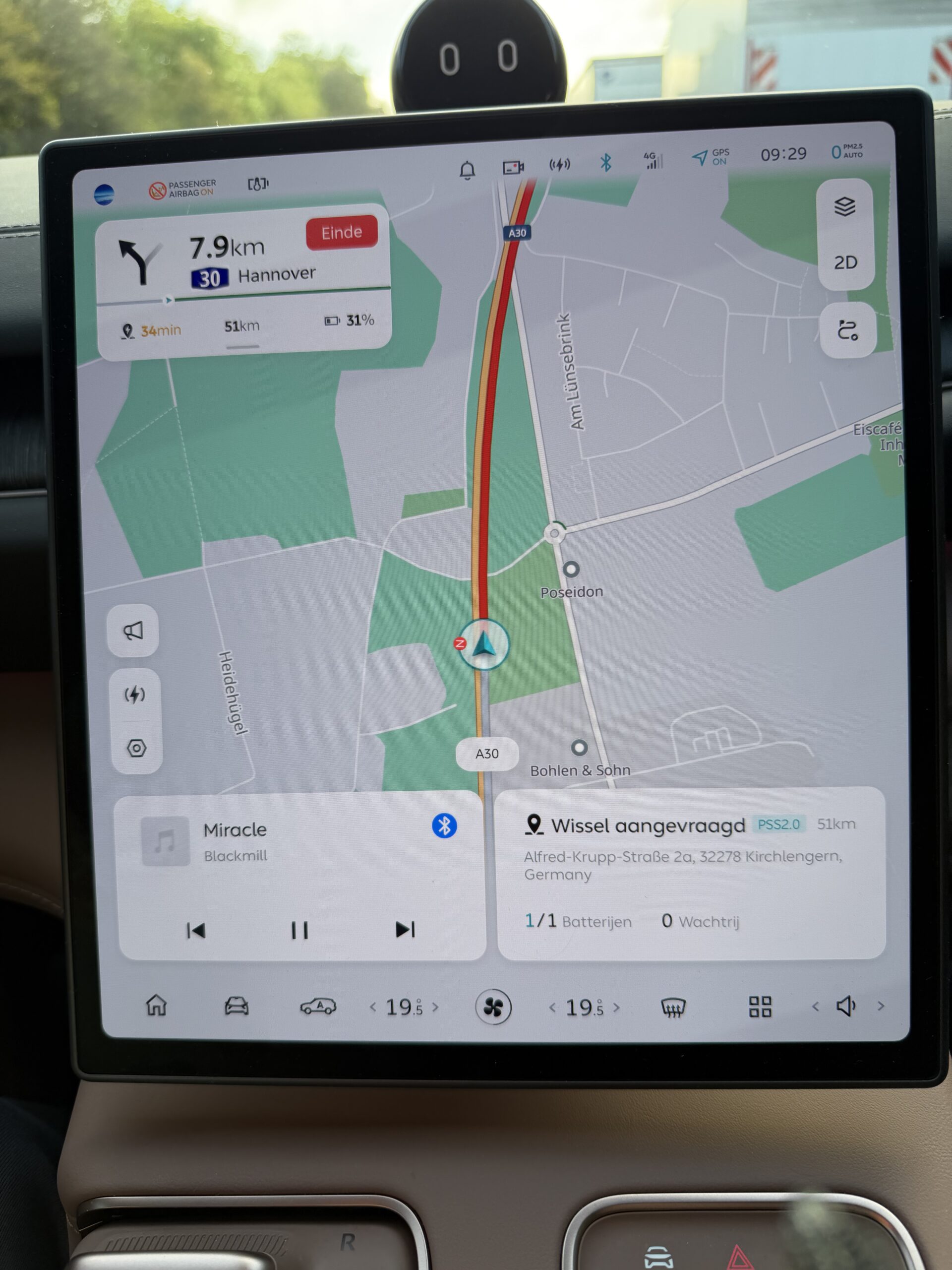 Infotainmentscherm van een auto met navigatie op de A30 richting Hannover en een melding voor een batterijwissel