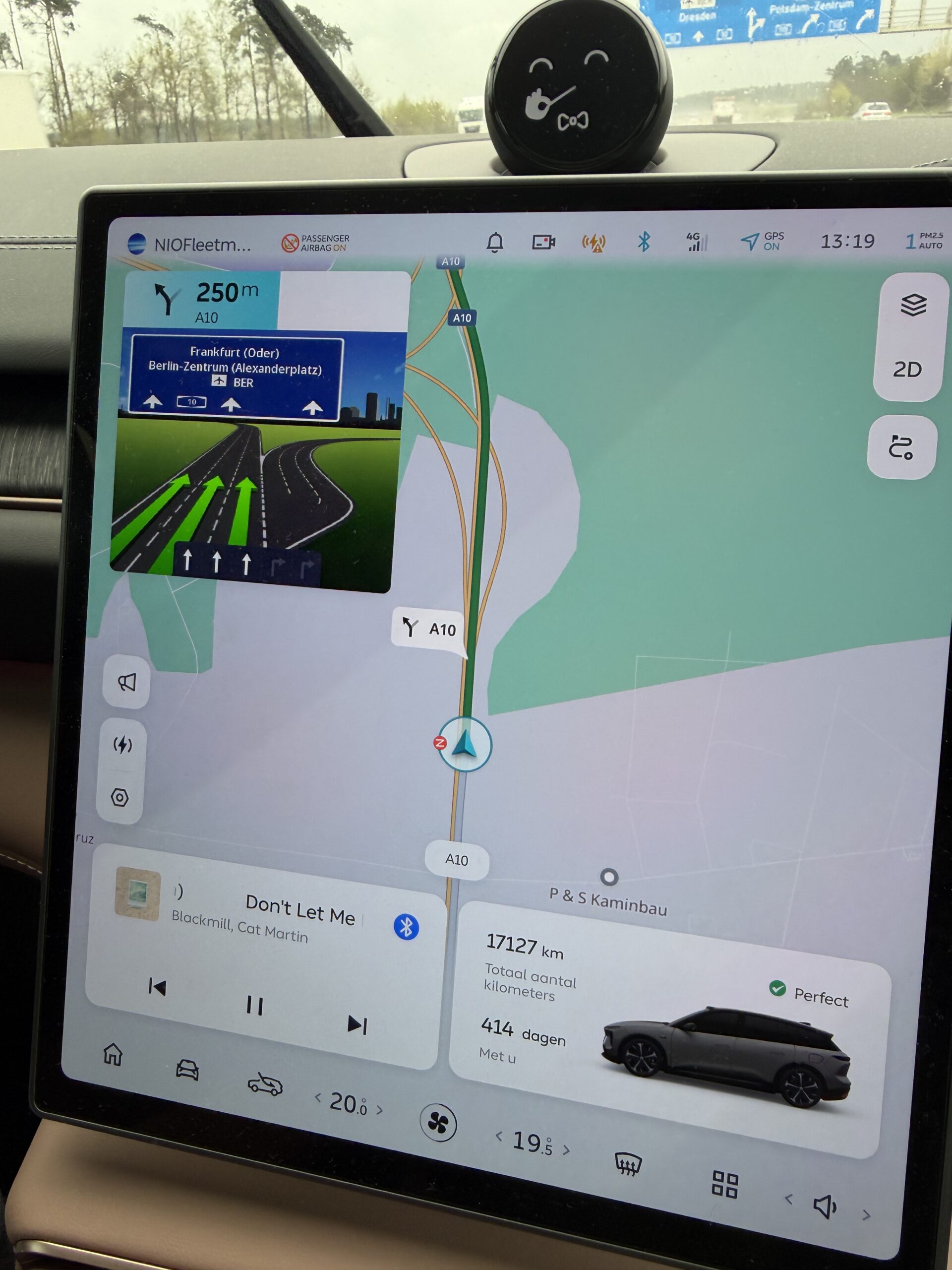 Infotainmentscherm van een NIO-auto met navigatie op de A10 richting Frankfurt (Oder) en Berlijn, muziek en voertuigstatus
