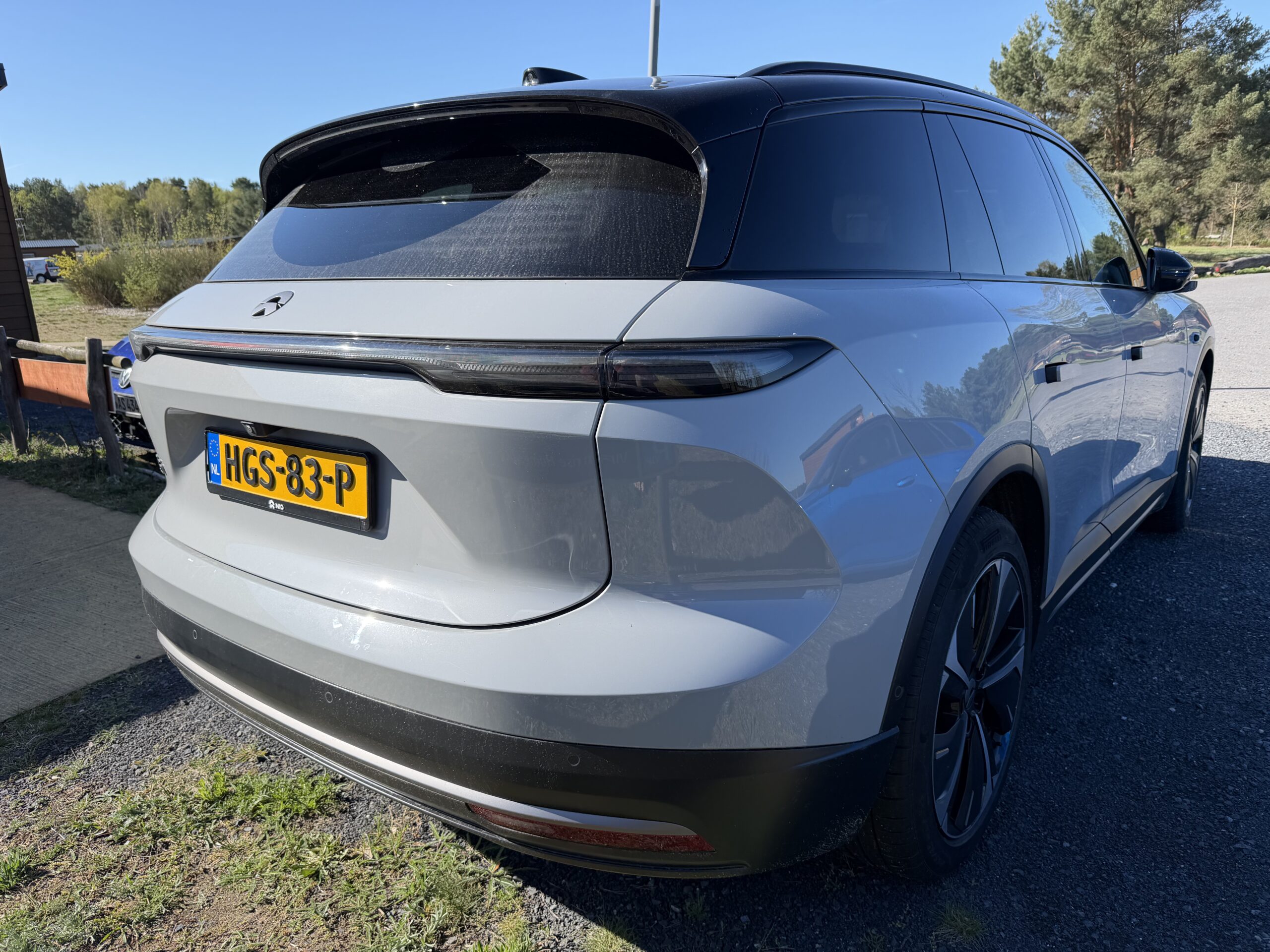 Achteraanzicht van een grijze Nio EL7 SUV met Nederlands kenteken HGS-83-P op een parkeerplaats