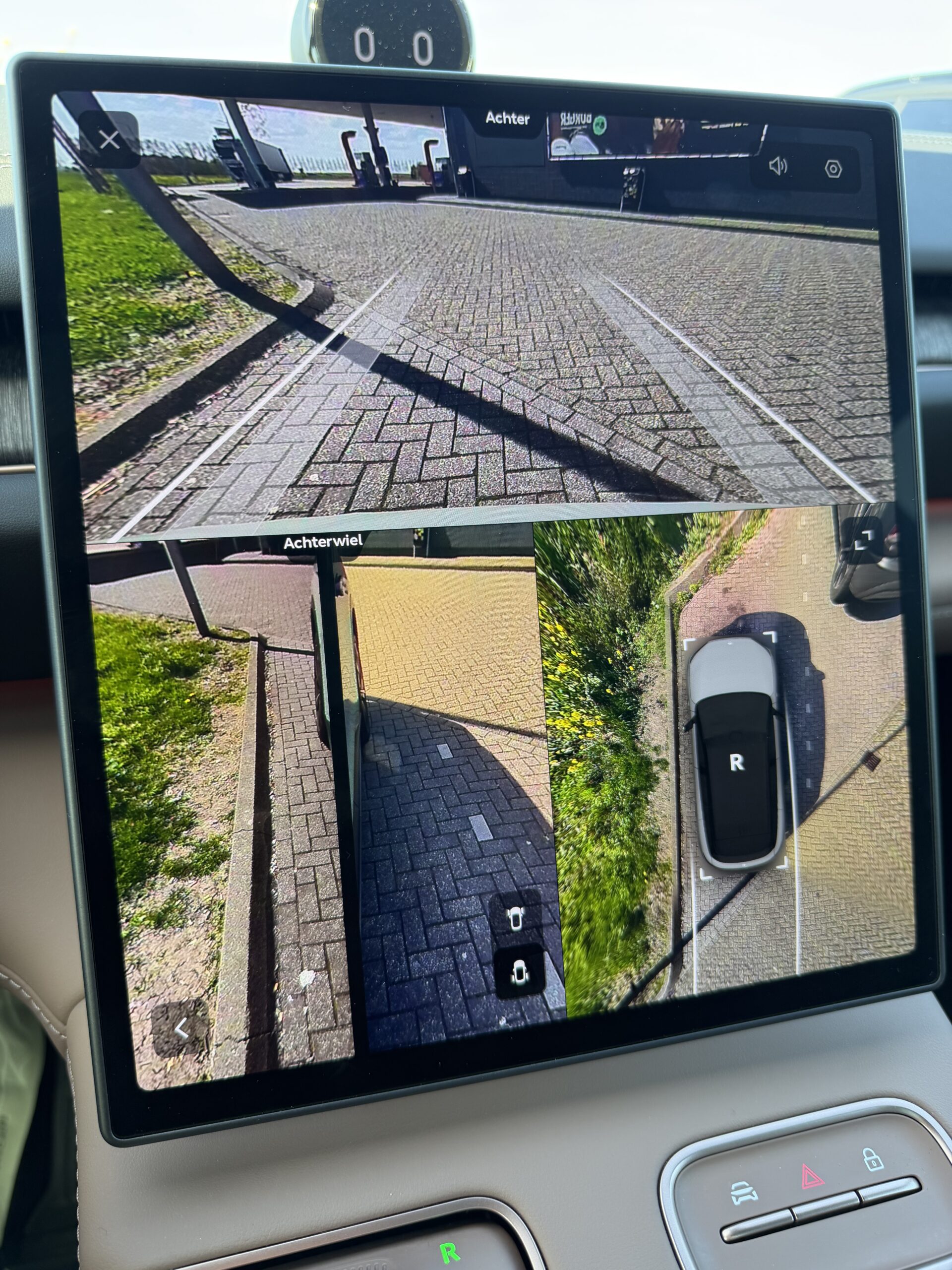 Dashboard-scherm van een auto met beelden van de achteruitrijcamera, zijcamera en een 360-graden bovenaanzicht