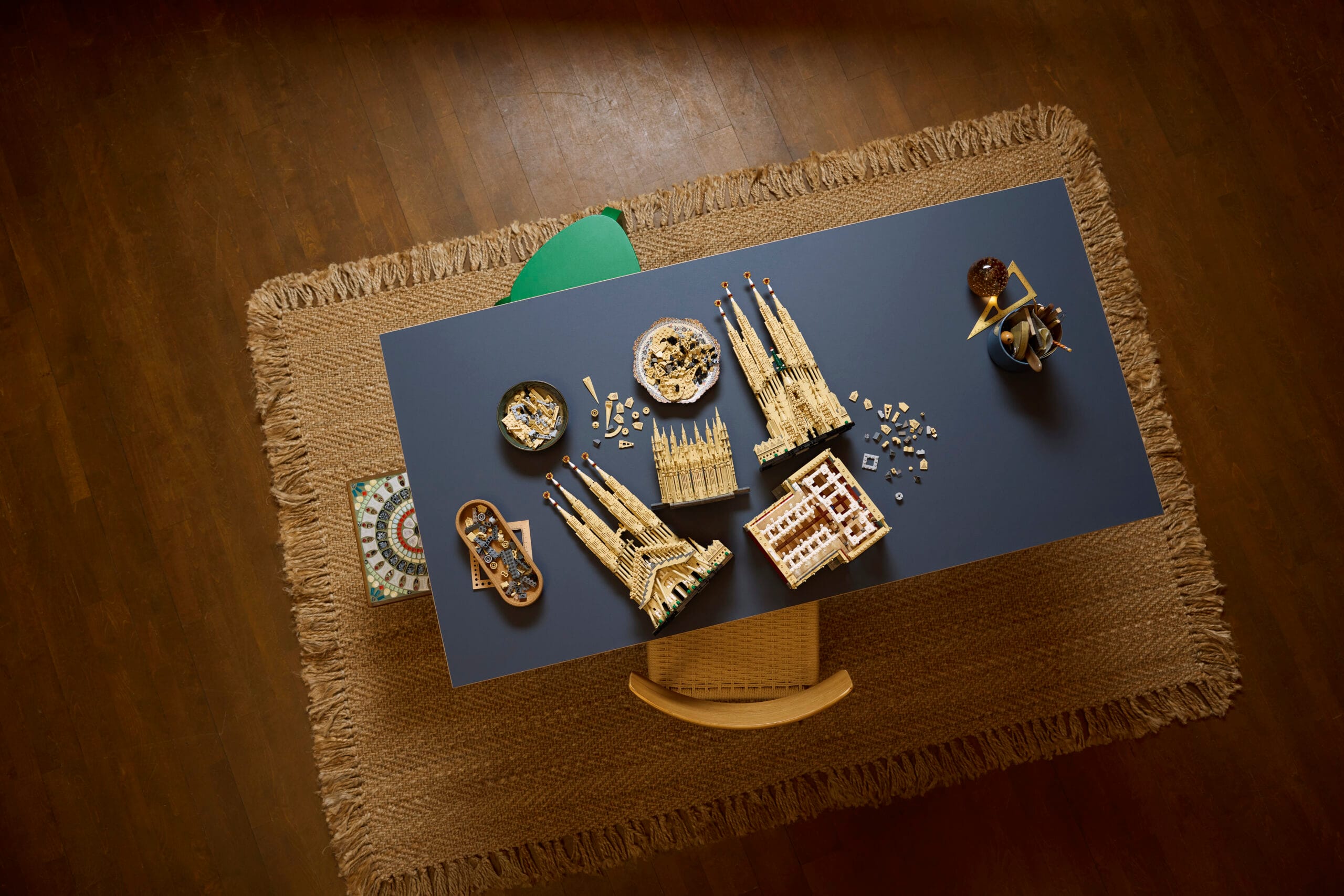 Bovenaanzicht van een deels voltooide LEGO set van de Sagrada Família op een blauwe tafel