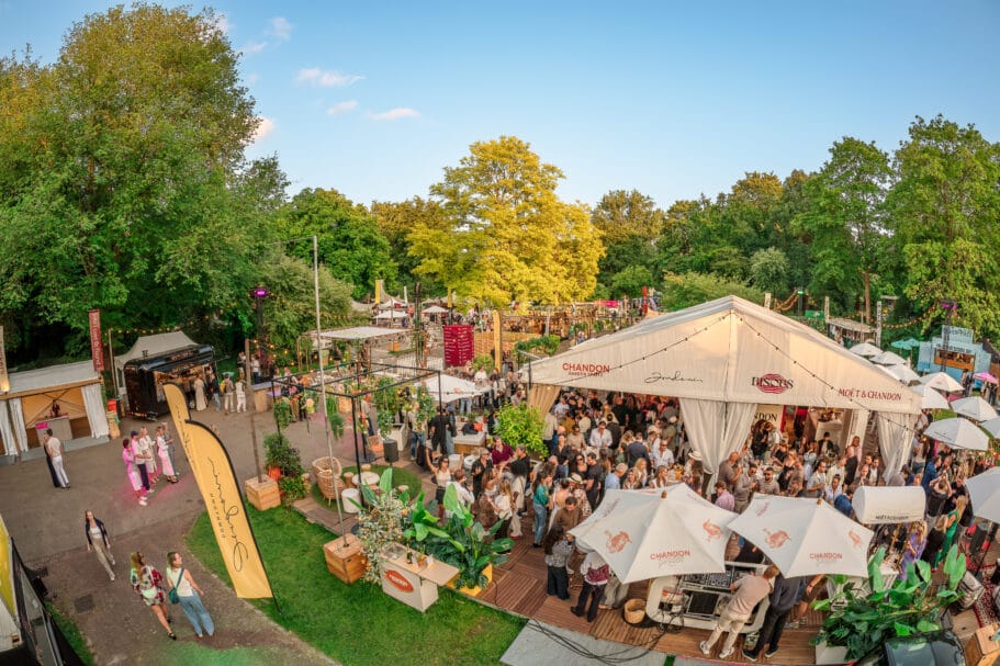 Bite of Amsterdam is een drukbezocht buitenfestival in het Amstelpark met witte partytenten, foodtrucks en mensen die samenkomen bij een bar