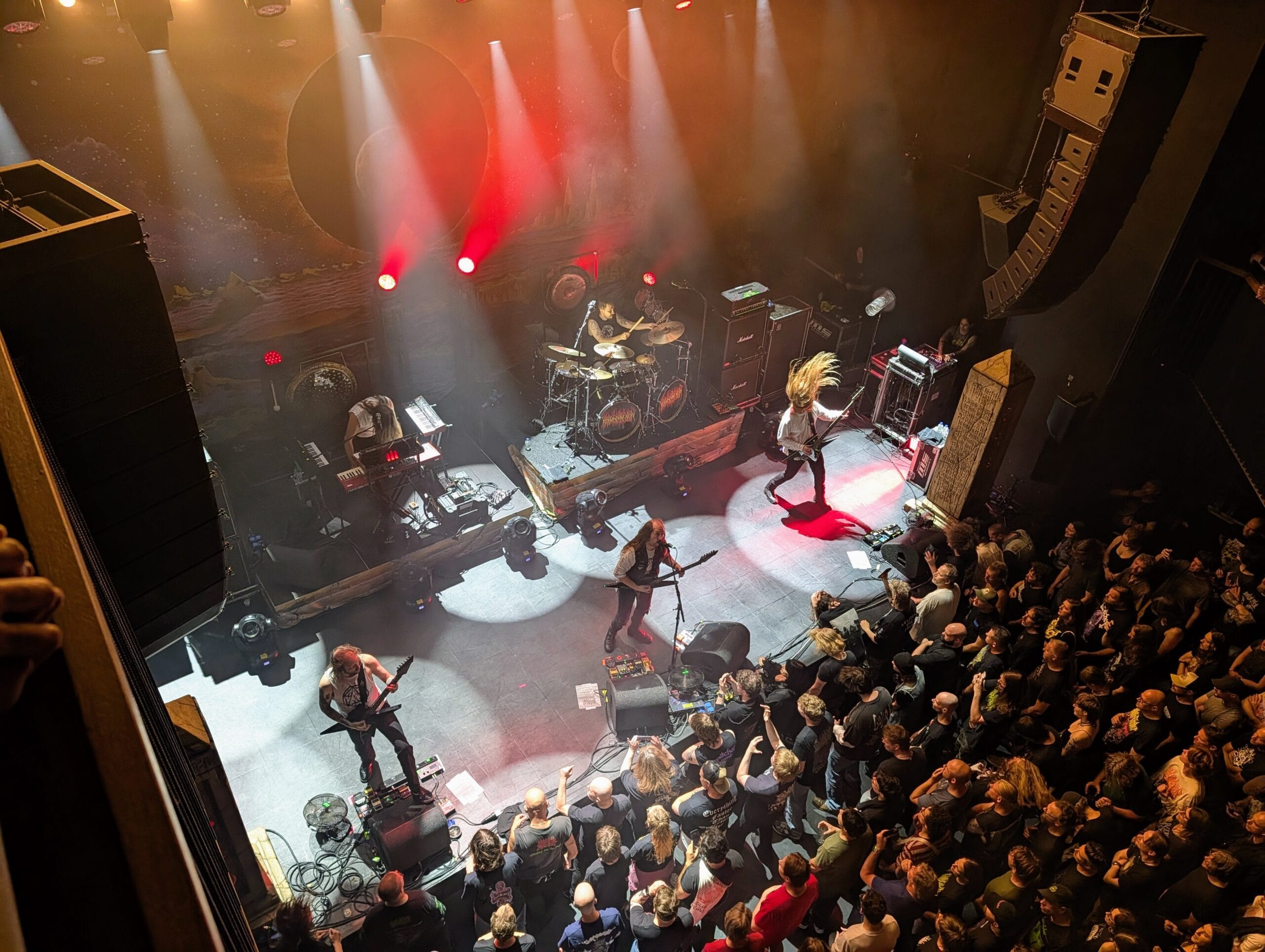 Blood Incantation treedt op een verlicht podium op voor een enthousiast publiek in een concertzaal