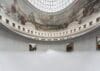 Een dikke laag witte mist vult de ronde centrale hal van de Bourse de Commerce onder een koepel met historische fresco's