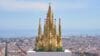 Een gedetailleerd LEGO-model van de Sagrada Família op een witte sokkel met de stad Barcelona op de achtergrond