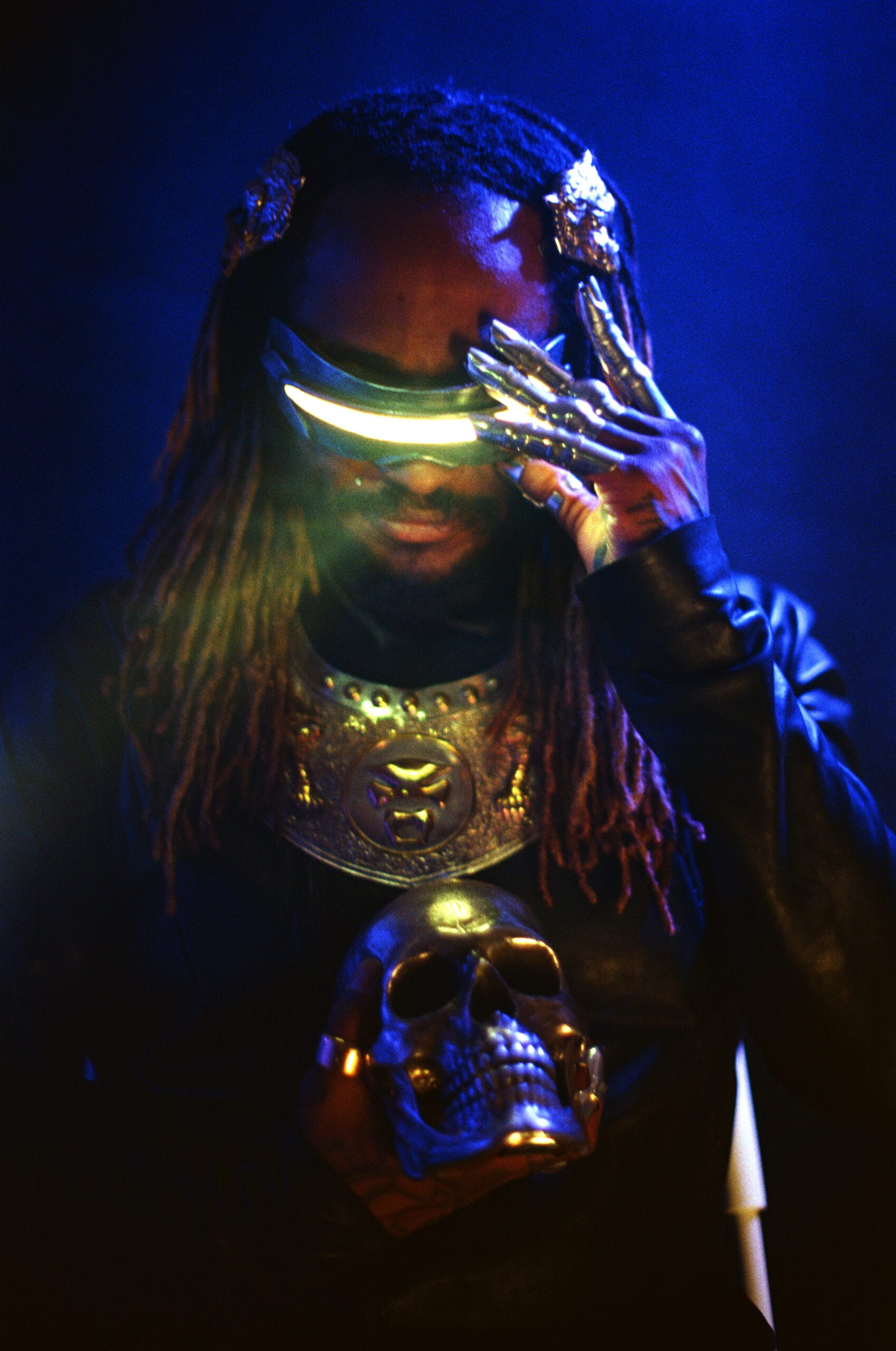 Thundercat met een lichtgevende futuristische bril, metalen handschoenen en een schedel in zijn handen