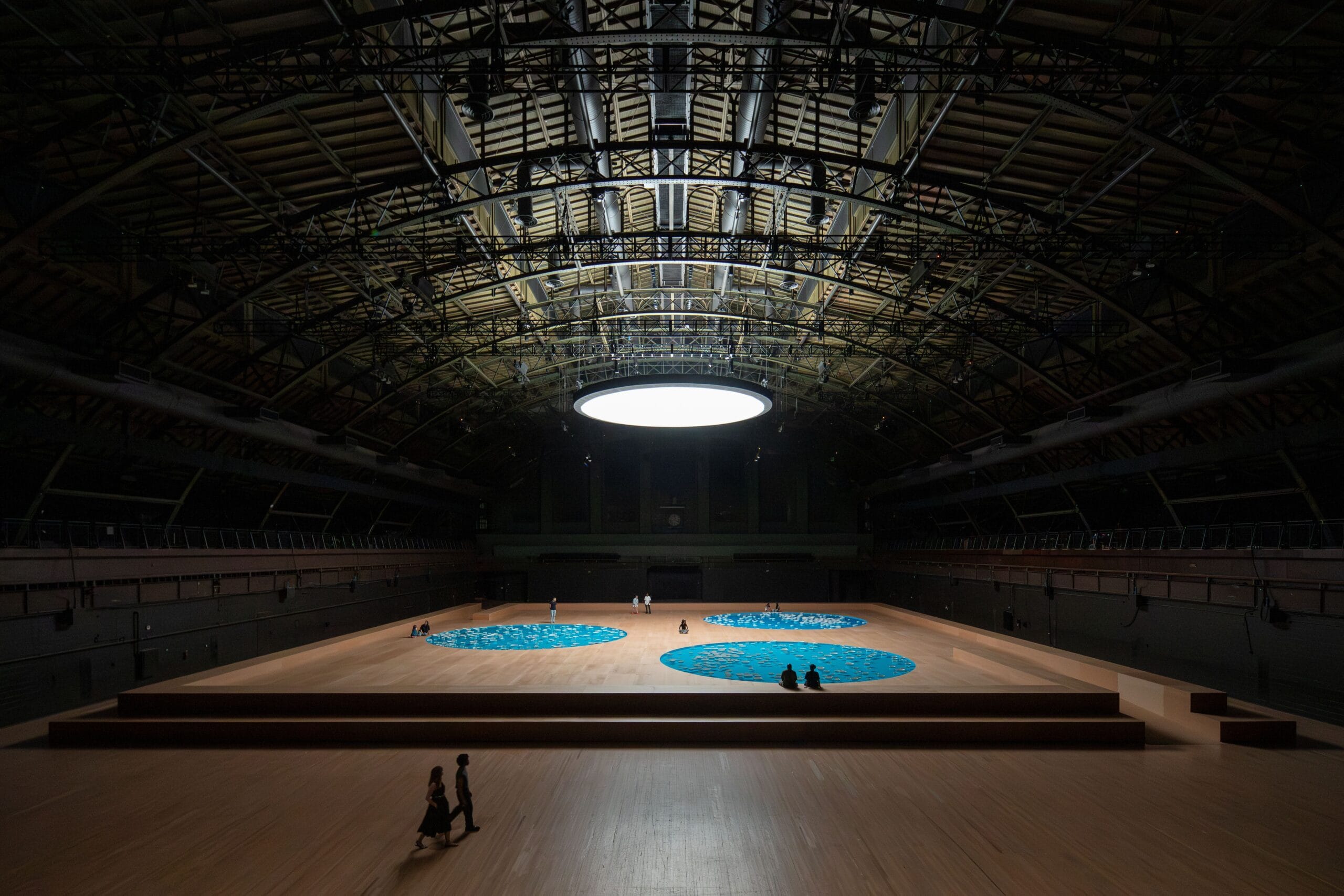 Overzicht van de installatie clinamen in de monumentale Wade Thompson Drill Hall met drie blauwe ronde waterbassins