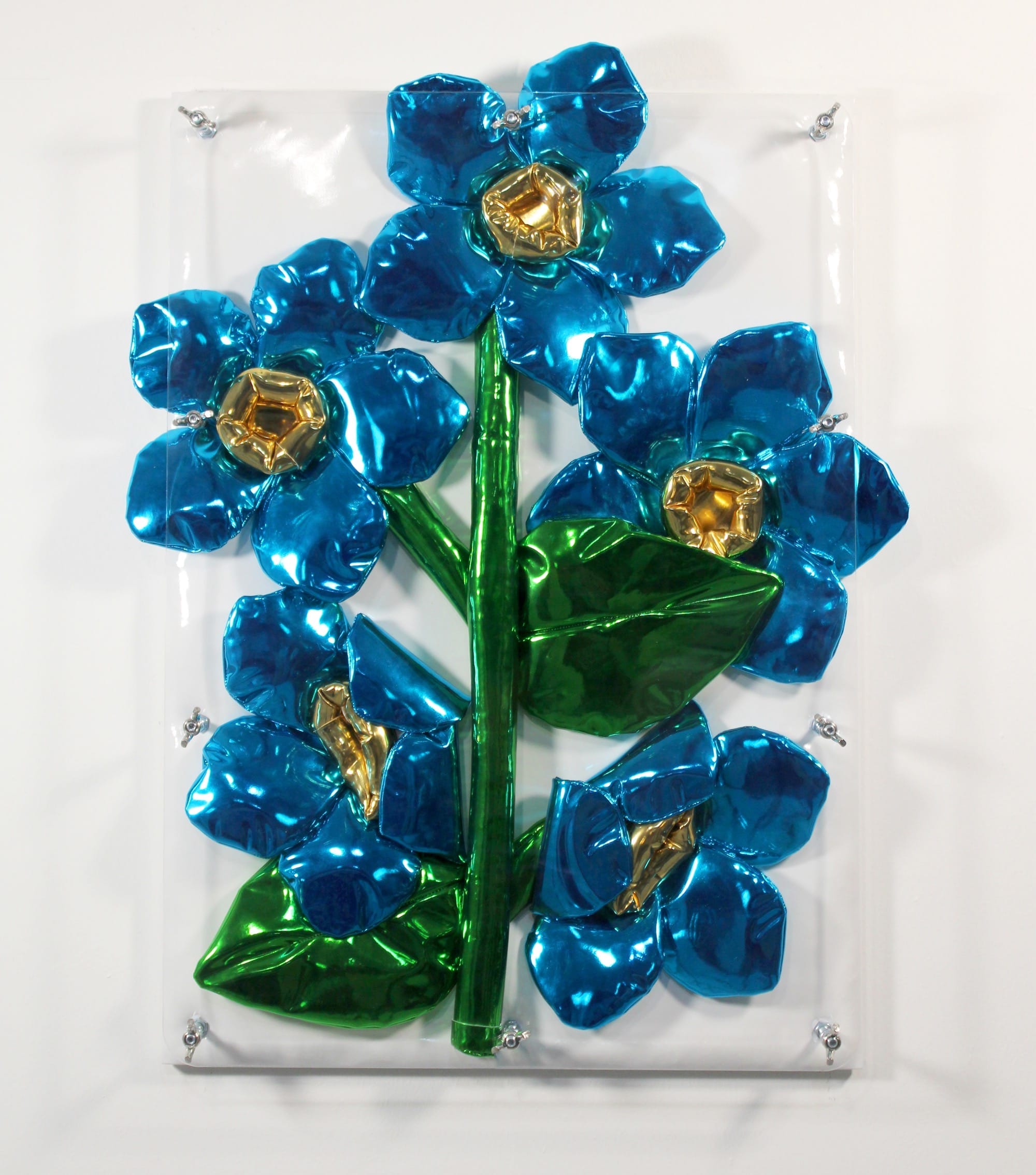Wandsculptuur van glanzende, blauwe metallic bloemen met gouden harten en groene bladeren op een witte achtergrond