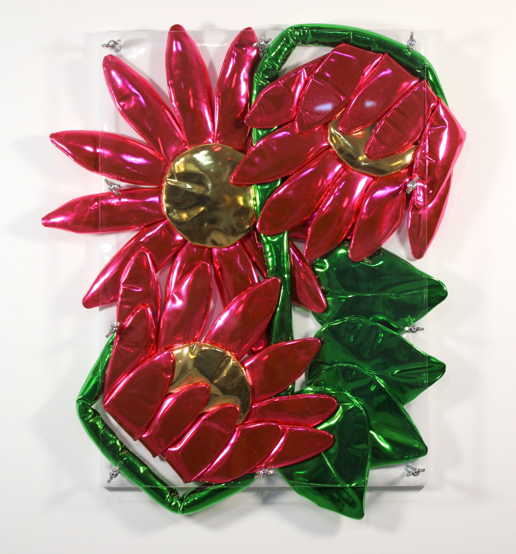 Wandsculptuur van glanzende, opblaasbare roze bloemen met gouden harten en groene bladeren achter plexiglas