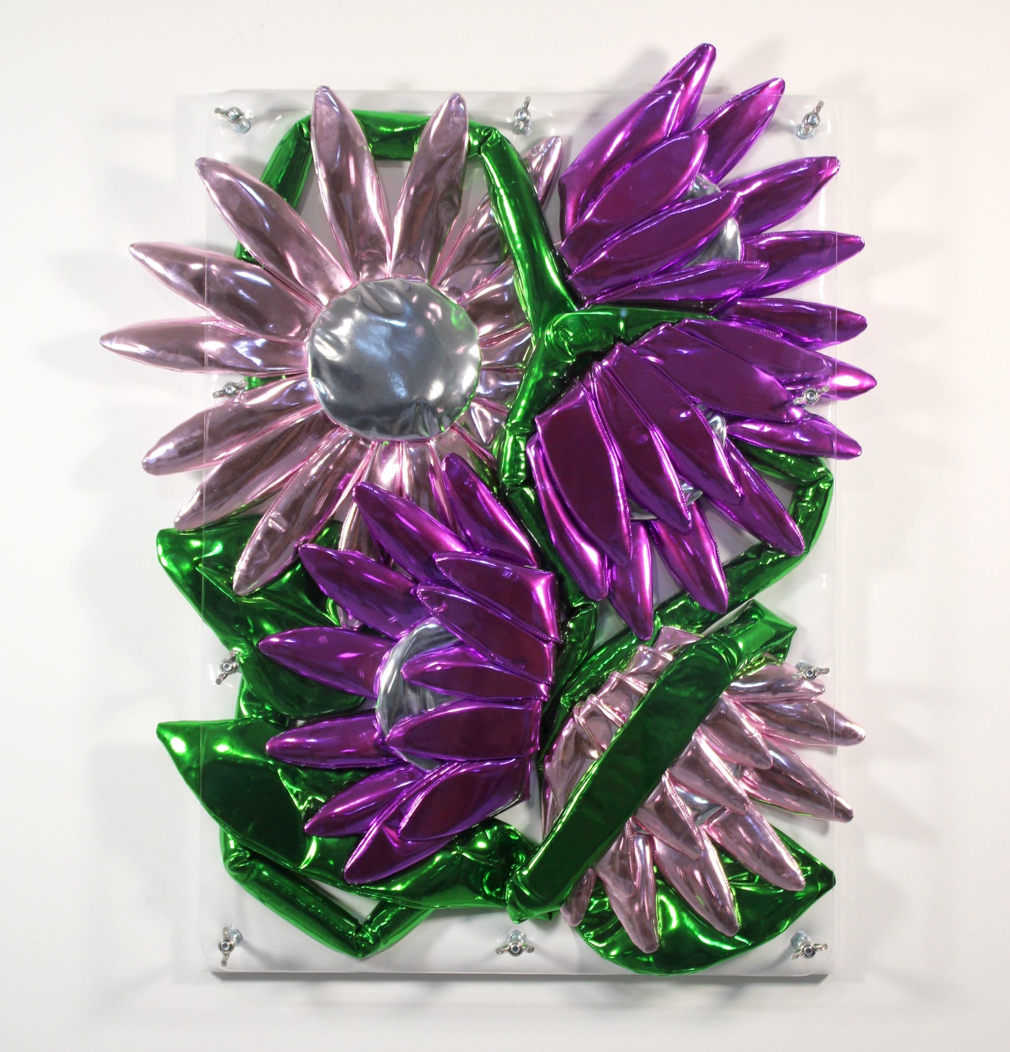 Wandsculptuur van glanzende, opgeblazen metalen bloemen in de kleuren roze, paars en groen