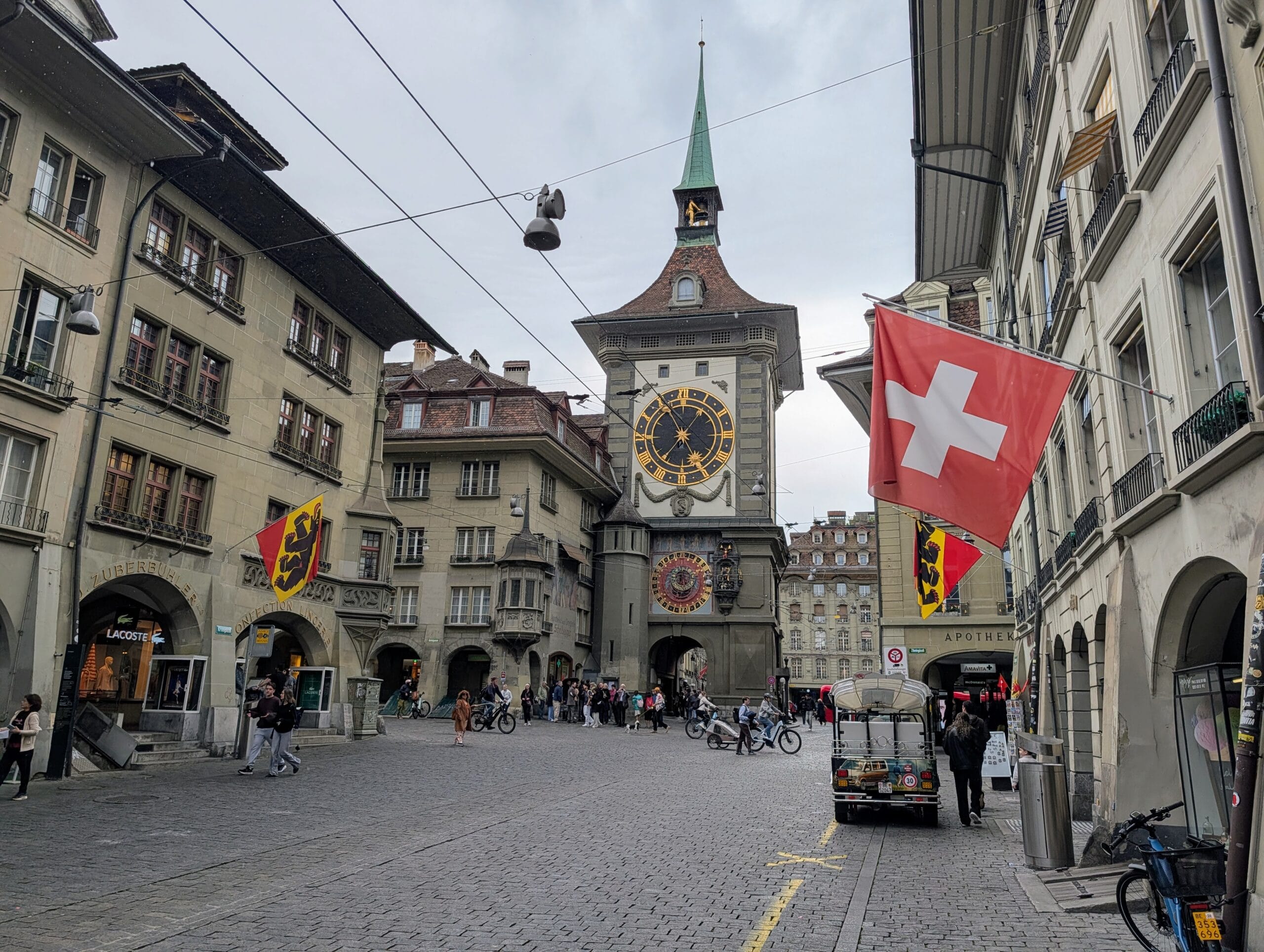 De Zytglogge-klokkentoren in het historische centrum van Bern met de Zwitserse vlag op de voorgrond