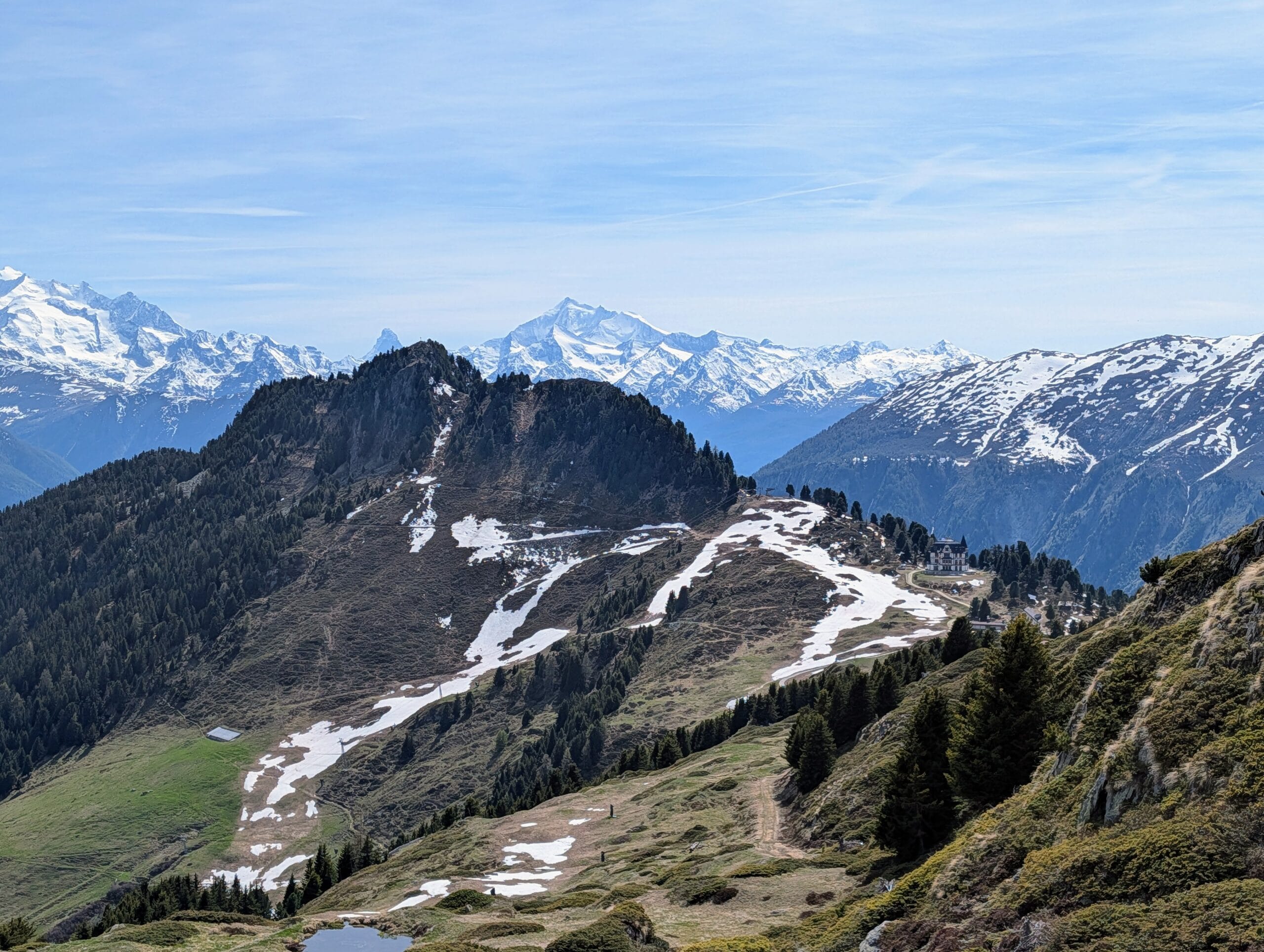 Panoramisch uitzicht op besneeuwde bergtoppen in de Alpen onder een helderblauwe lucht