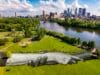 Luchtfoto van een gigantische muurschildering van in elkaar grijpende handen op het gras in een park in Minneapolis
