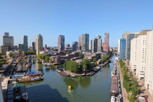 Luchtfoto van de Wijnhaven in Rotterdam met moderne wolkenkrabbers, wooncomplexen en diverse schepen in het water