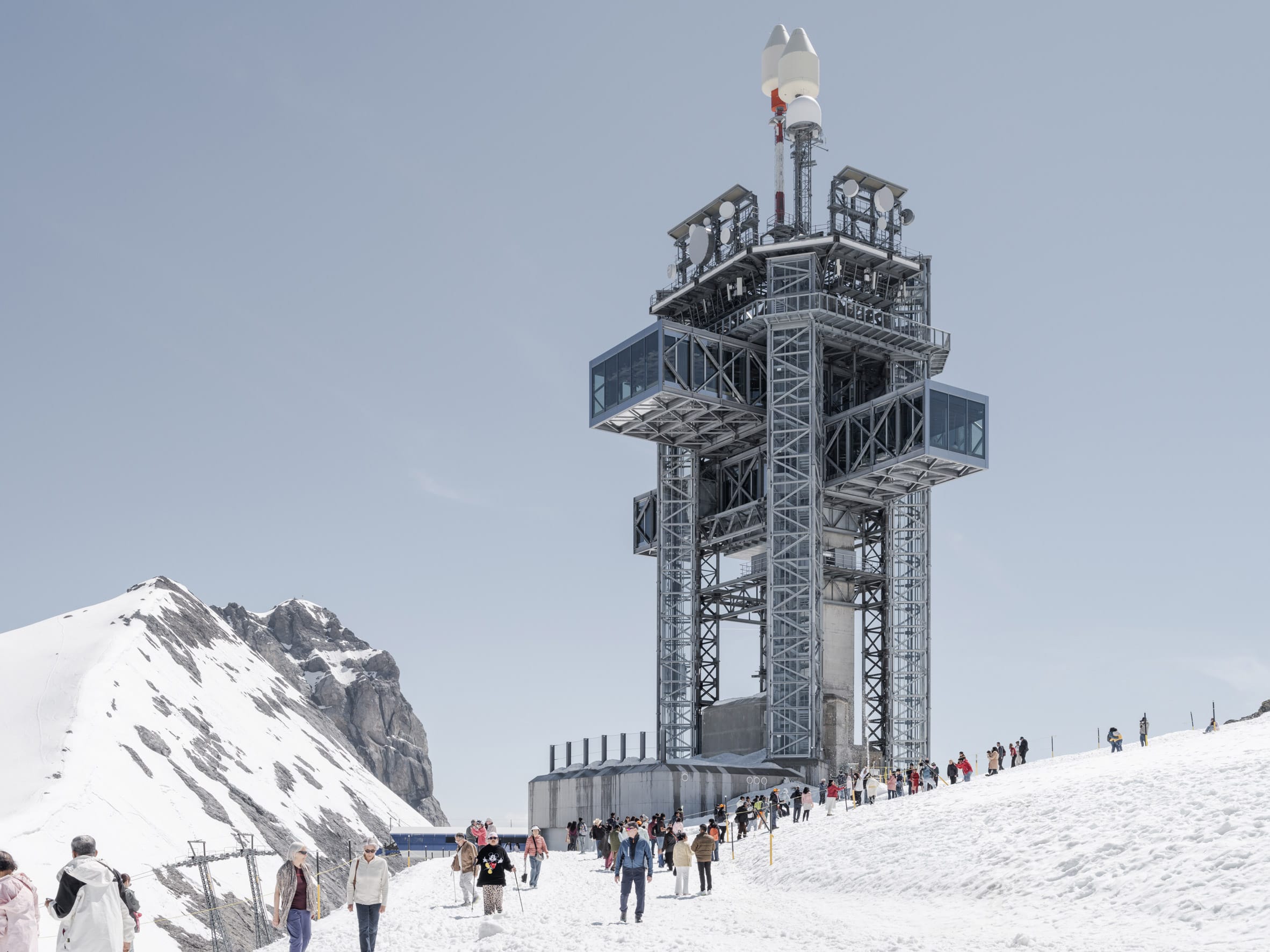 Een panoramisch overzicht van de nieuwe moderne Titlis Tower op de besneeuwde top van de berg Titlis in Zwitserland, afstekend tegen een helderblauwe lucht