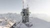 Een modern weerstation en zendmast met glazen uitkijkplatforms op een besneeuwde bergtop in de Alpen