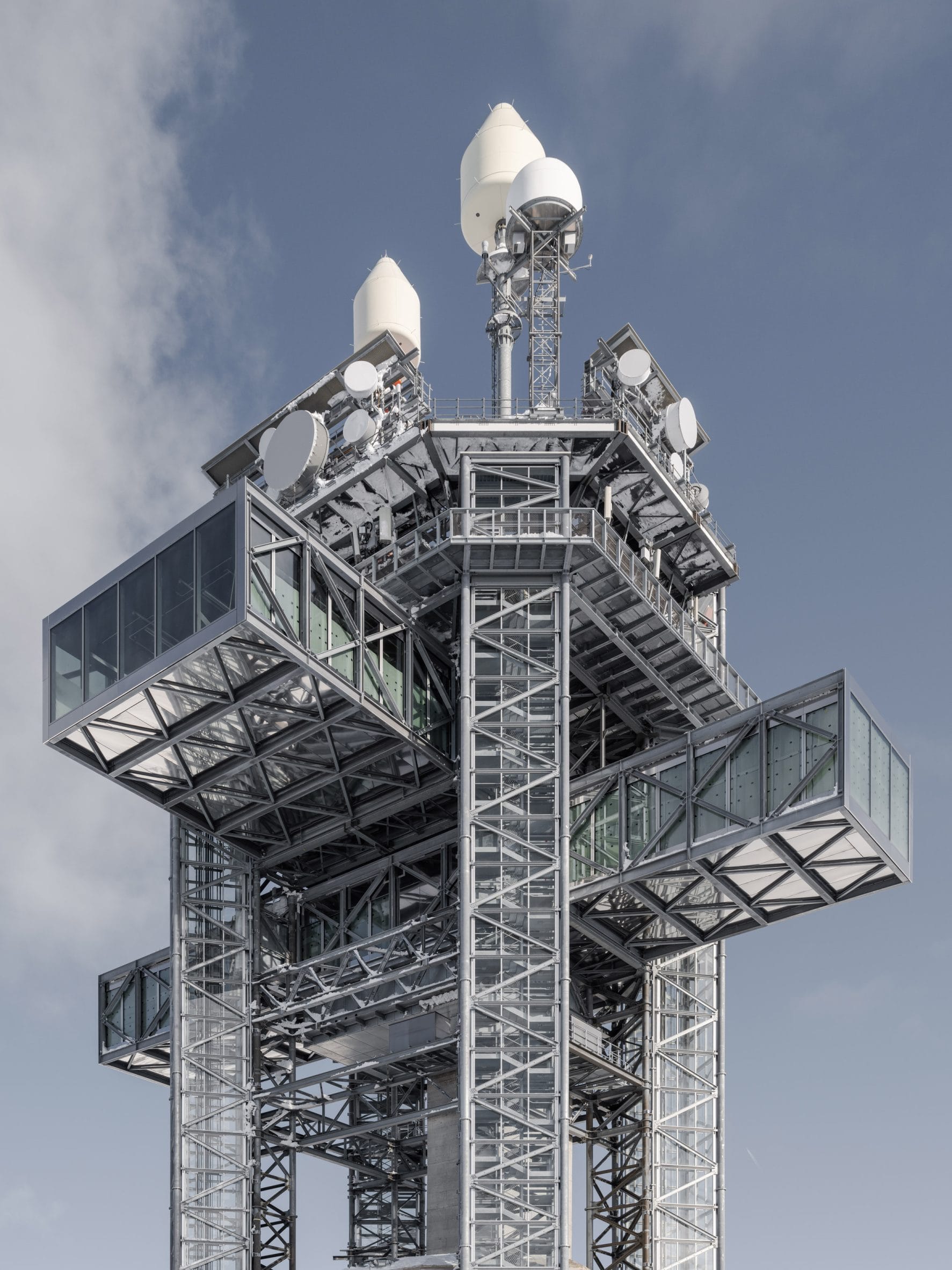 Een panoramisch overzicht van de nieuwe moderne Titlis Tower op de besneeuwde top van de berg Titlis in Zwitserland, afstekend tegen een helderblauwe lucht