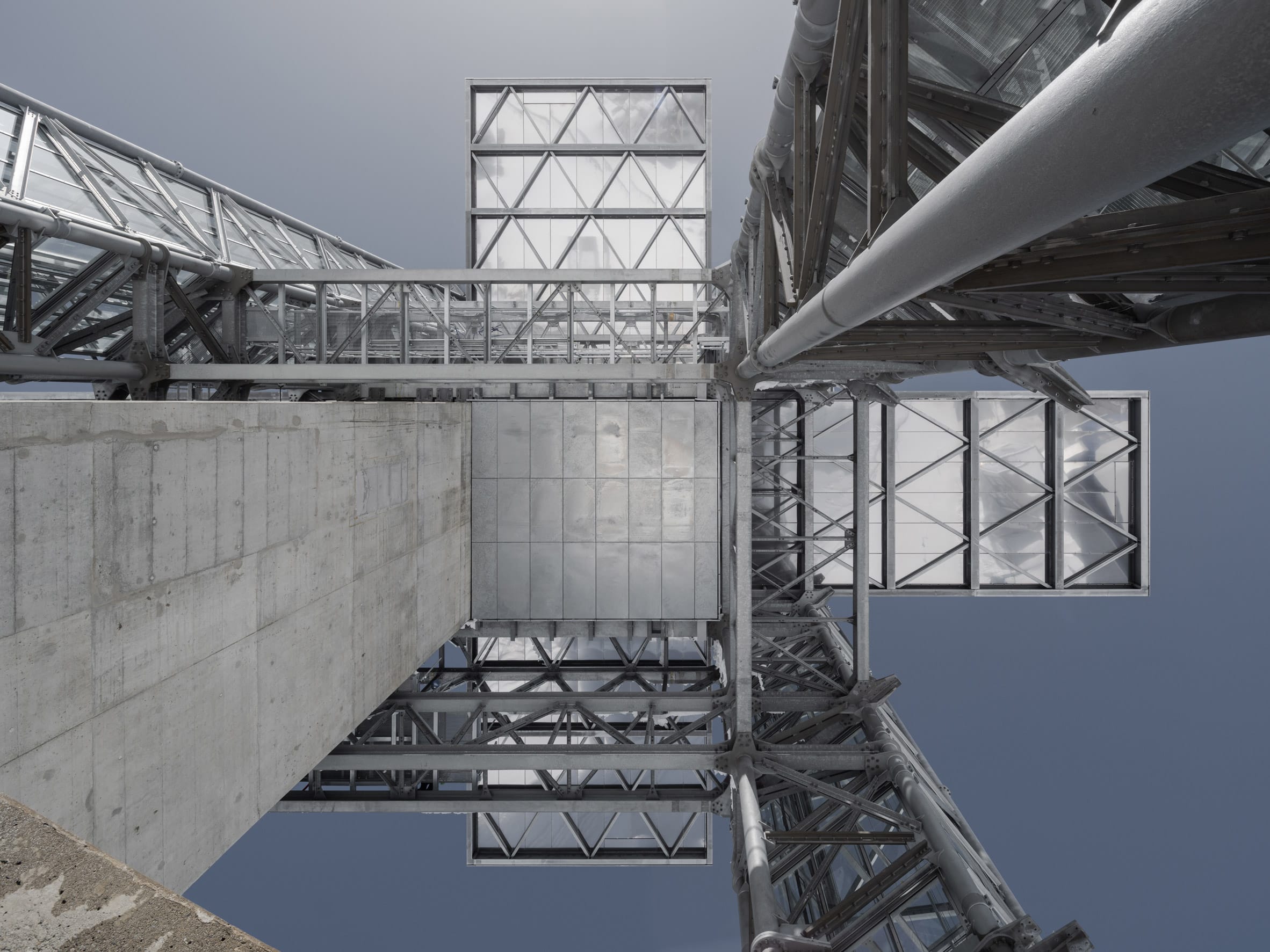 Het strakke, kruisvormige ontwerp van de nieuwe Titlis Tower in Zwitserland, waarbij de moderne lijnen contrasteren met de rotsachtige bergwand.