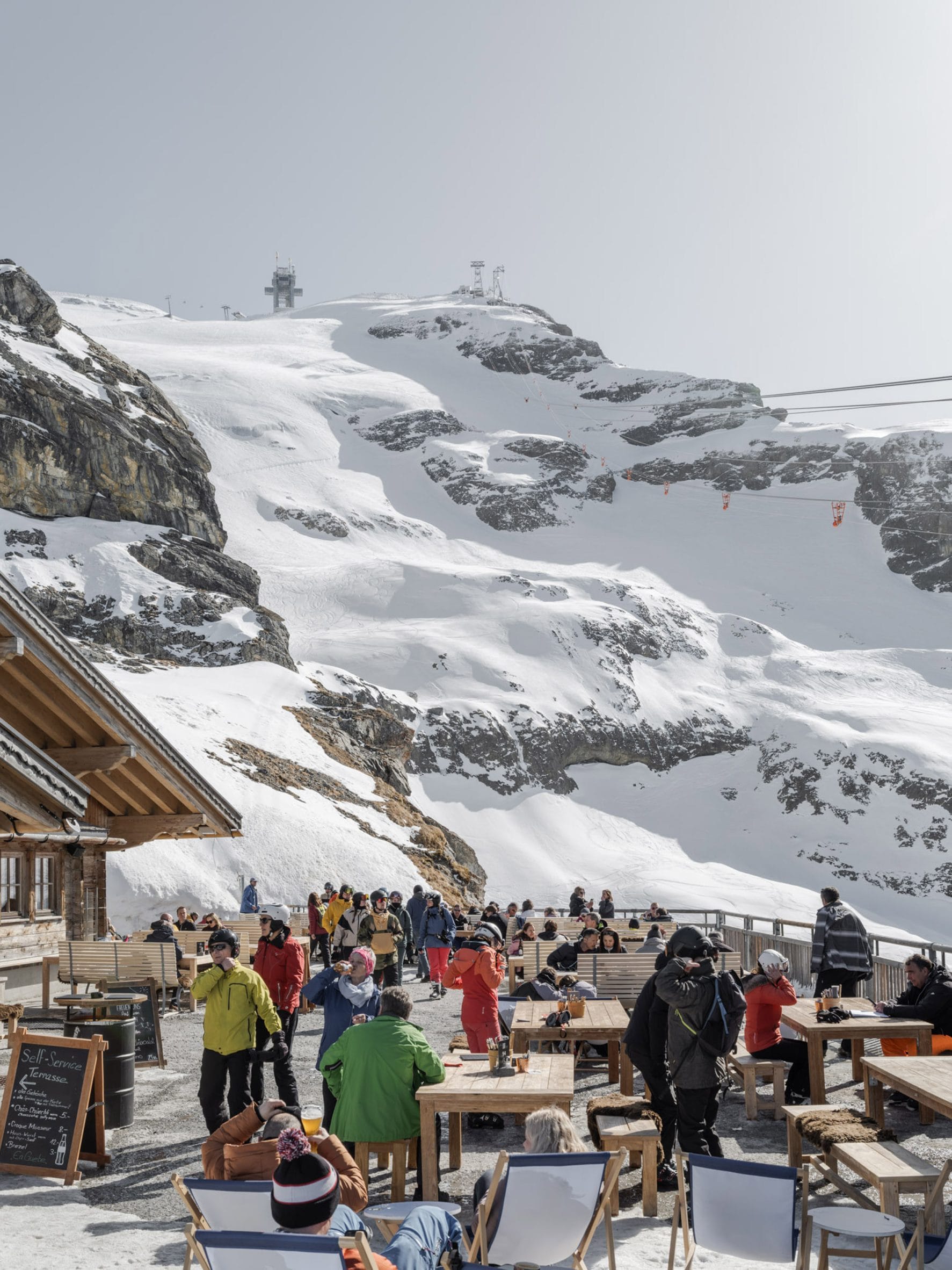Een panoramisch overzicht van de nieuwe moderne Titlis Tower op de besneeuwde top van de berg Titlis in Zwitserland, afstekend tegen een helderblauwe lucht